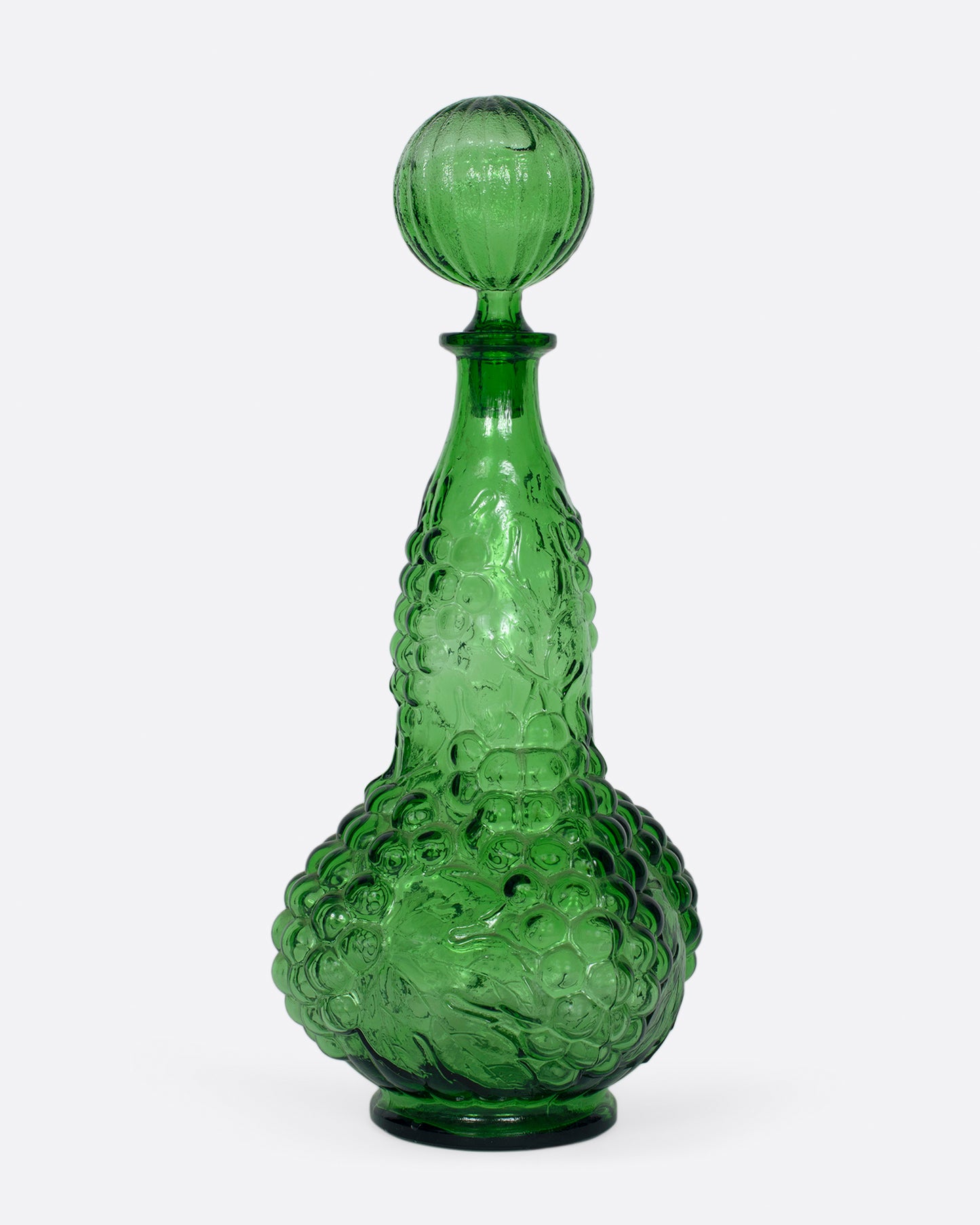 A tall, bottle green glass decanter with a textured stopper.