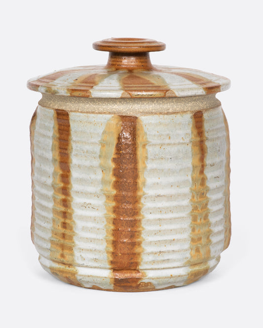 This vintage ceramic dried goods jar has a ribbed texture and a hand painted orange-slice design that adds a bit of sunshine to your counter.