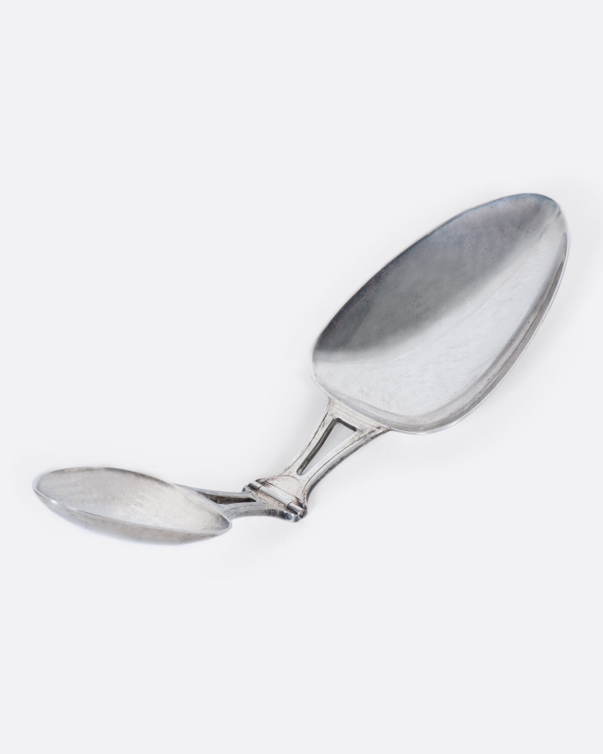 A sterling silver folding spoon with a teaspoon on one side and a tablespoon on the other.