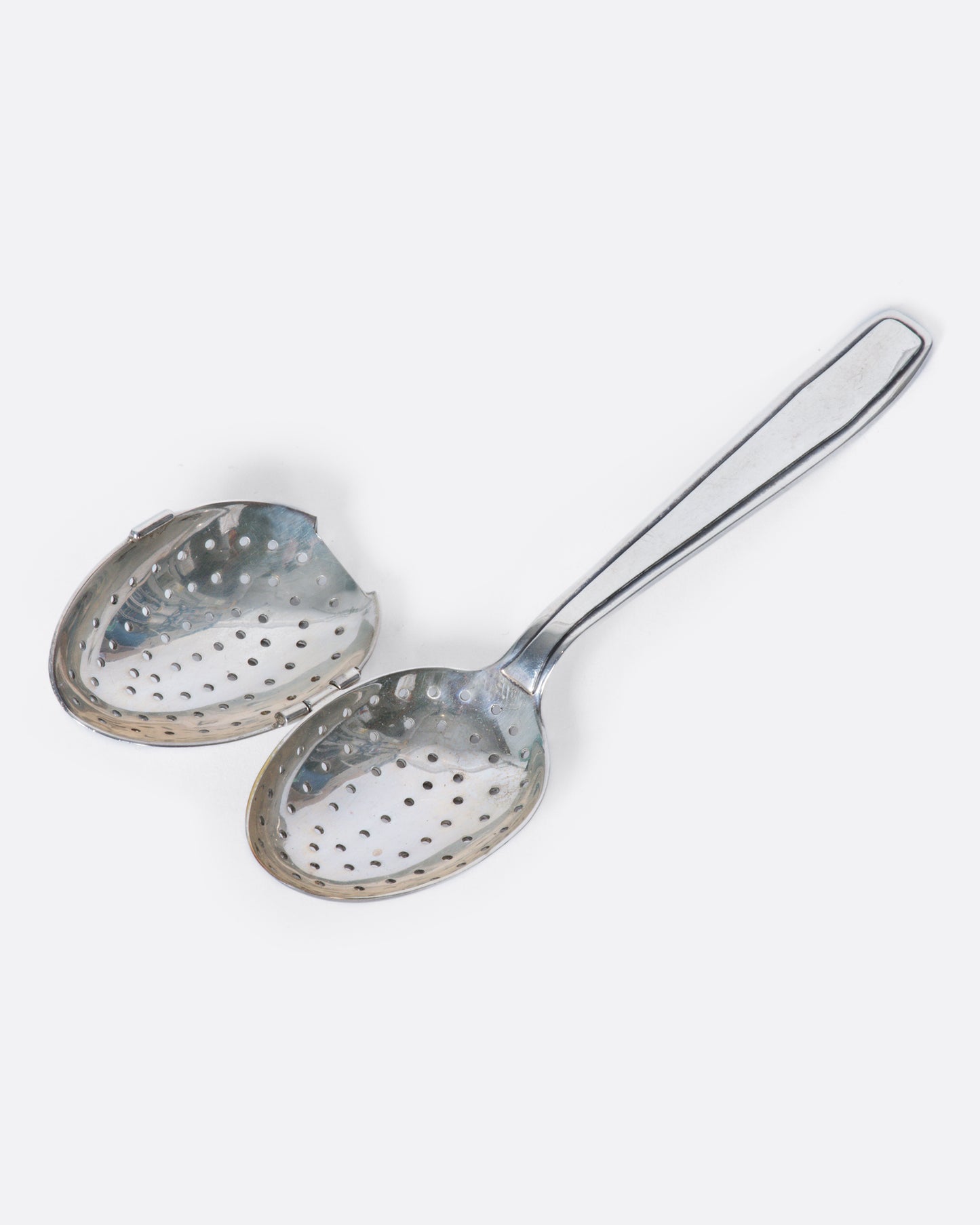 A perforated sterling silver spoon with a hinged perforated lid to create a tea diffuser.