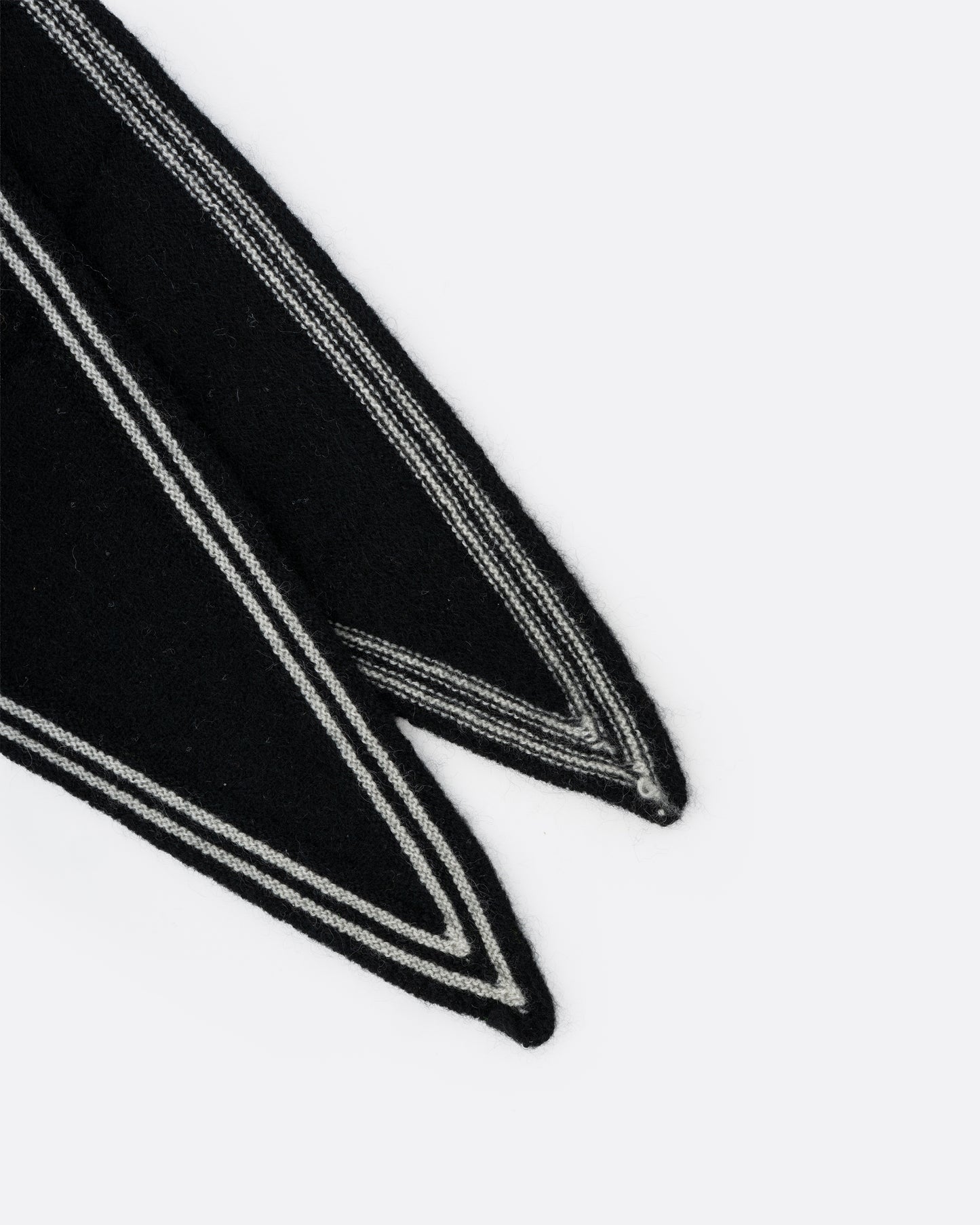 A close up of a cashmere black neck scarf with stripy white edges.