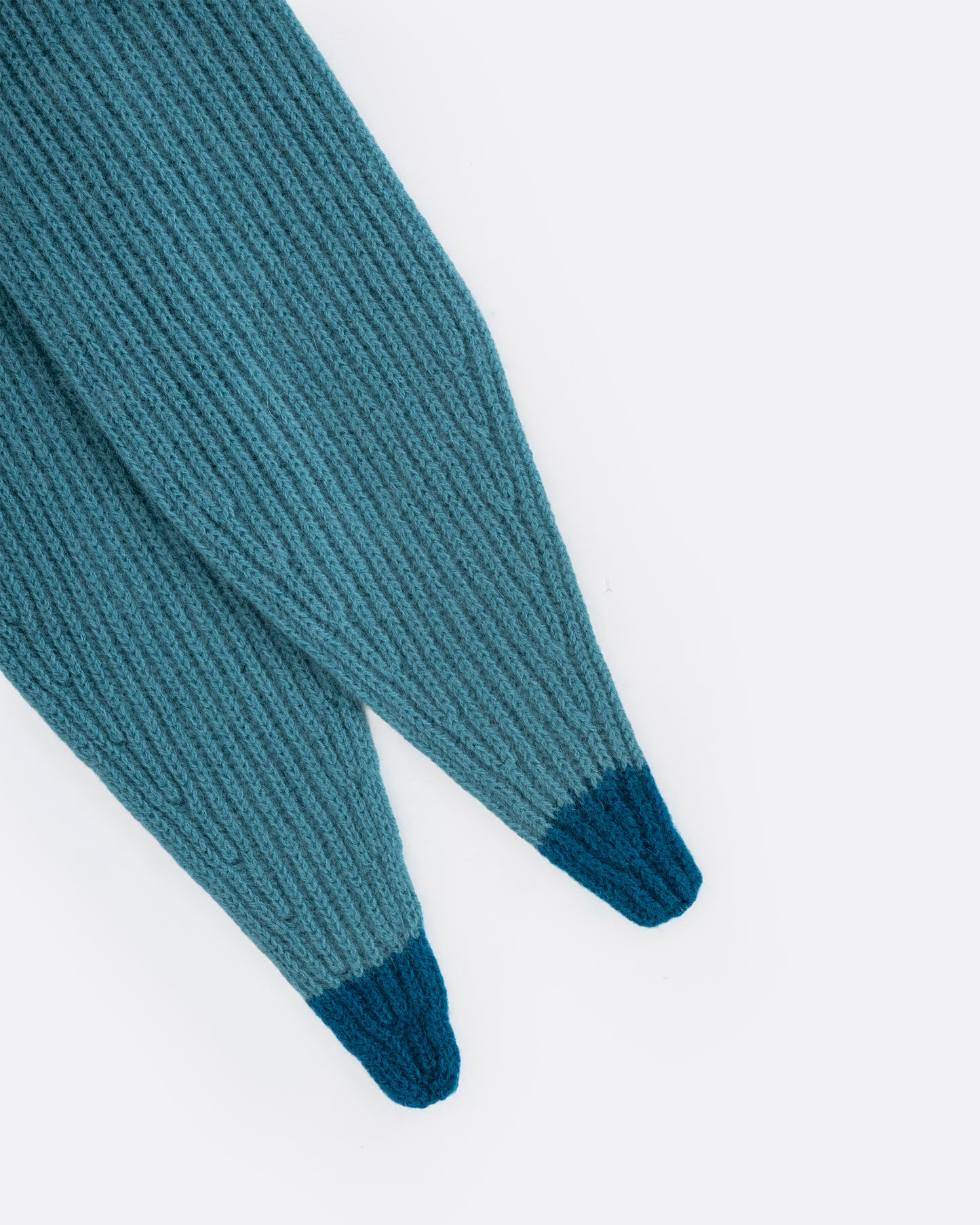 A close up of a teal cashmere scarf with blue tips.