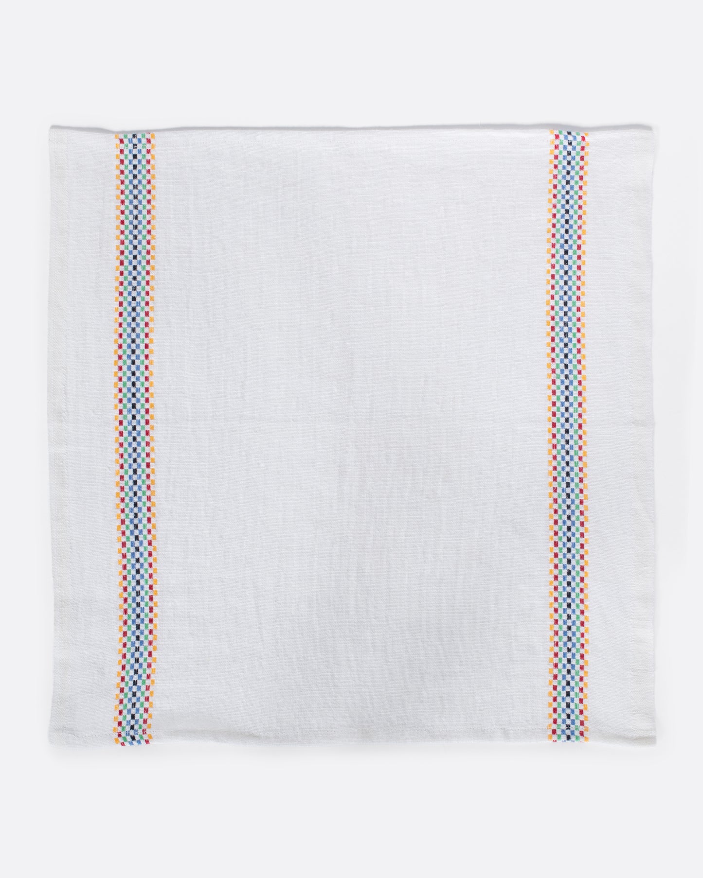 A white linen napkin with rainbow checkered embroidered stripes