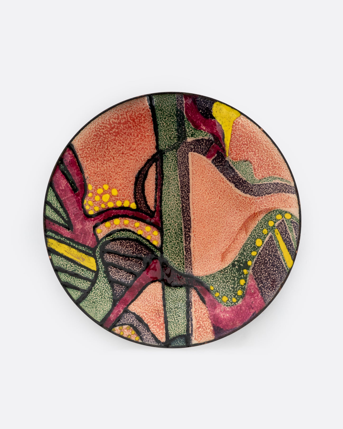 A metal and enamel plate with an abstract graphic design in orange purple, green, and yellow. Shown from the top.
