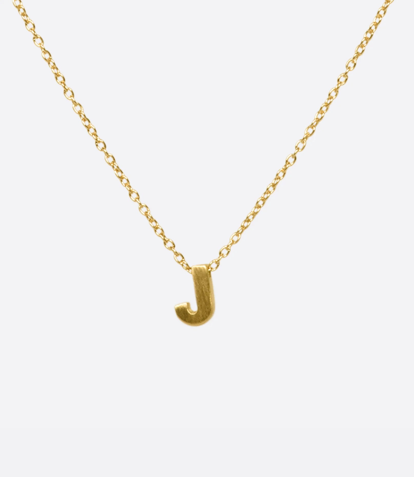 A yellow gold cable chain necklace with a letter J initial pendant. Shown from the front.