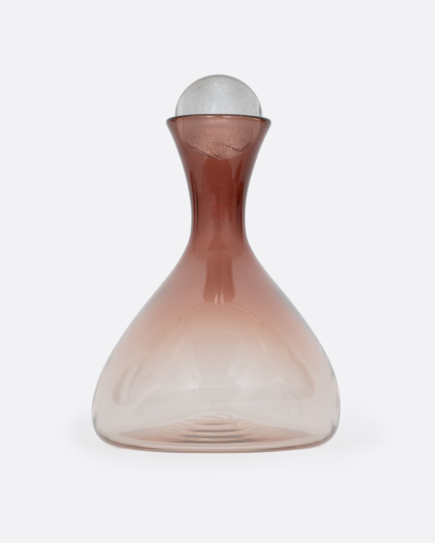 A blown glass decanter in an aubergine gradient with a wide base and a round silver stopper, shown from the side.
