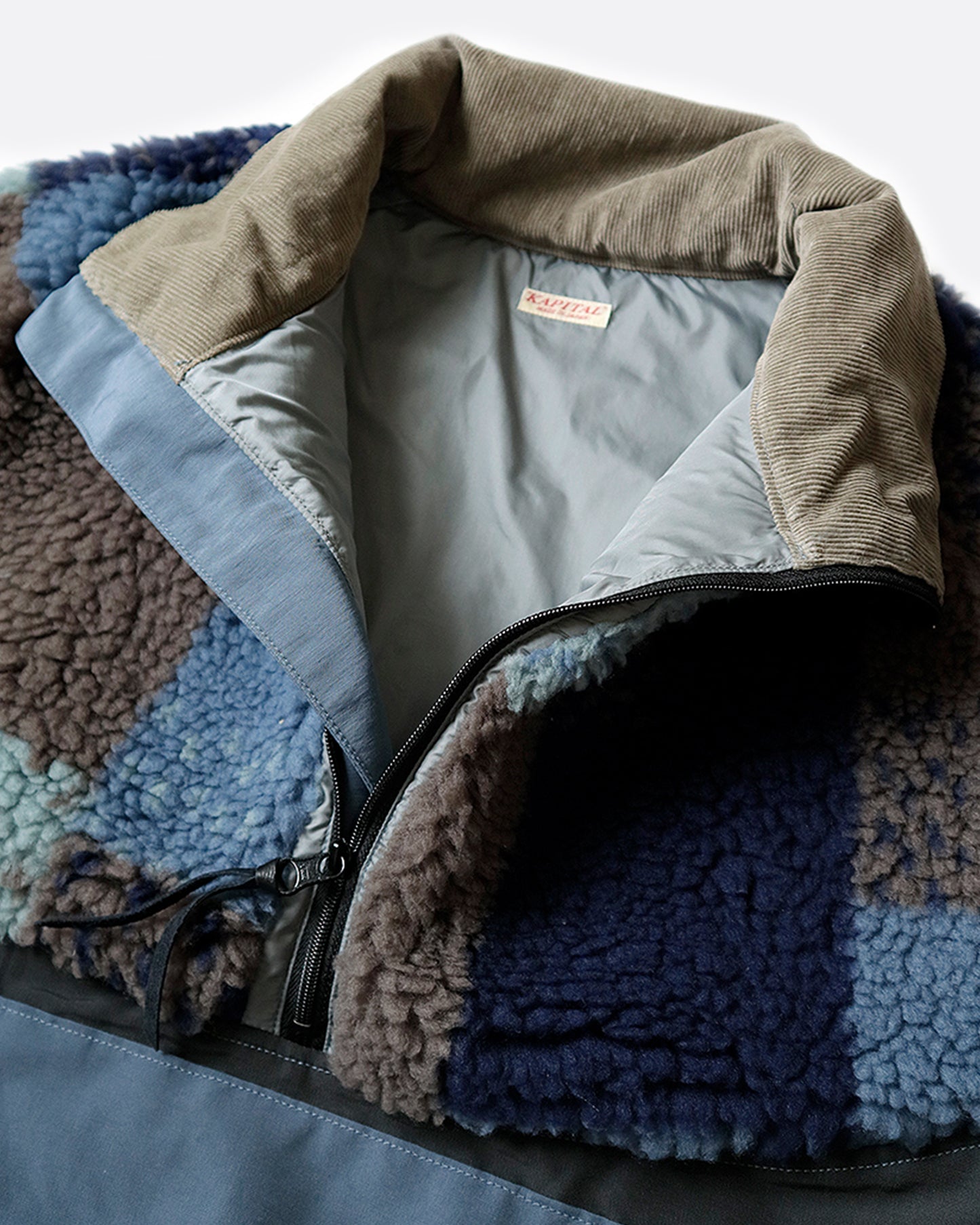 A close up on the gray corduroy collar of the 60/40 two-tone fleece anorak. Shown from the front.