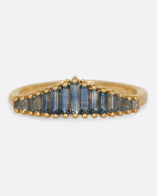 A crown ring covered in teal blue sapphire baguettes.
