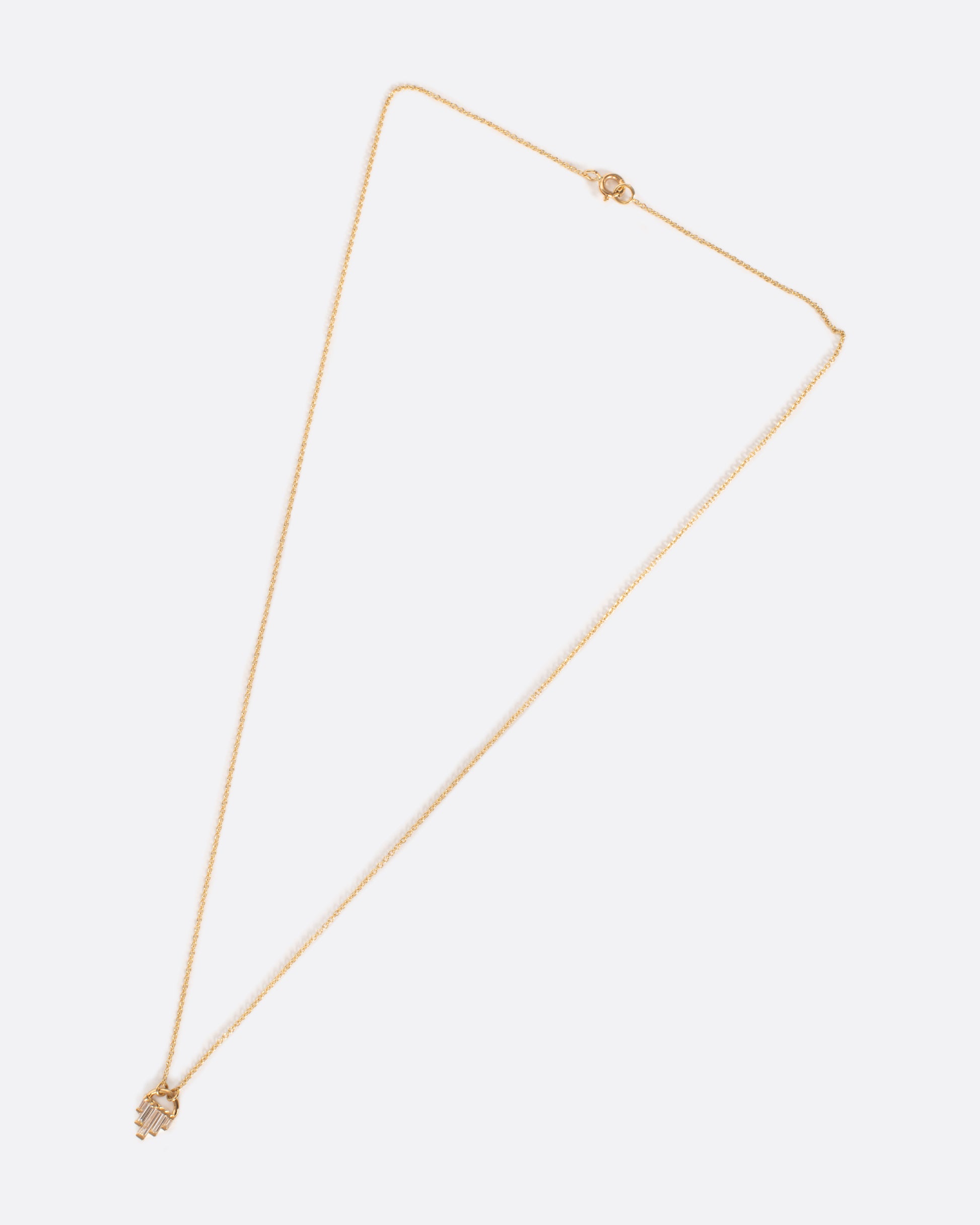 A curved gold pendant necklace with gradient in size baguette diamonds.