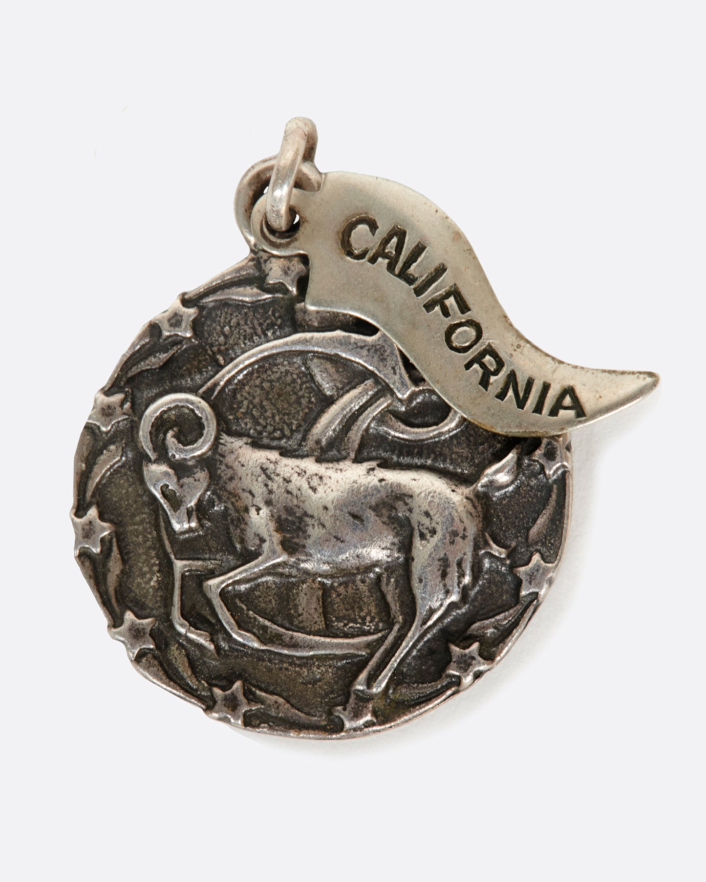 A round medal pendant with your zodiac sign and a California pennant.