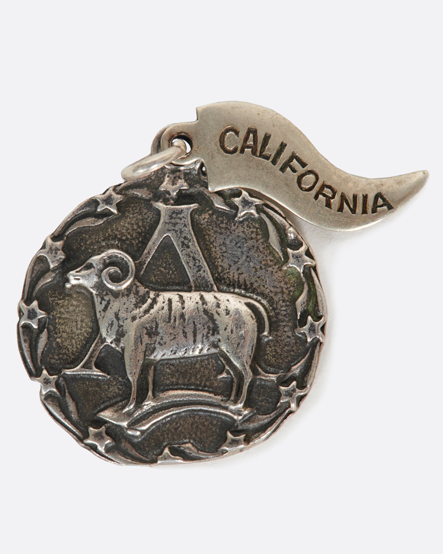 A round medal pendant with your zodiac sign and a California pennant.