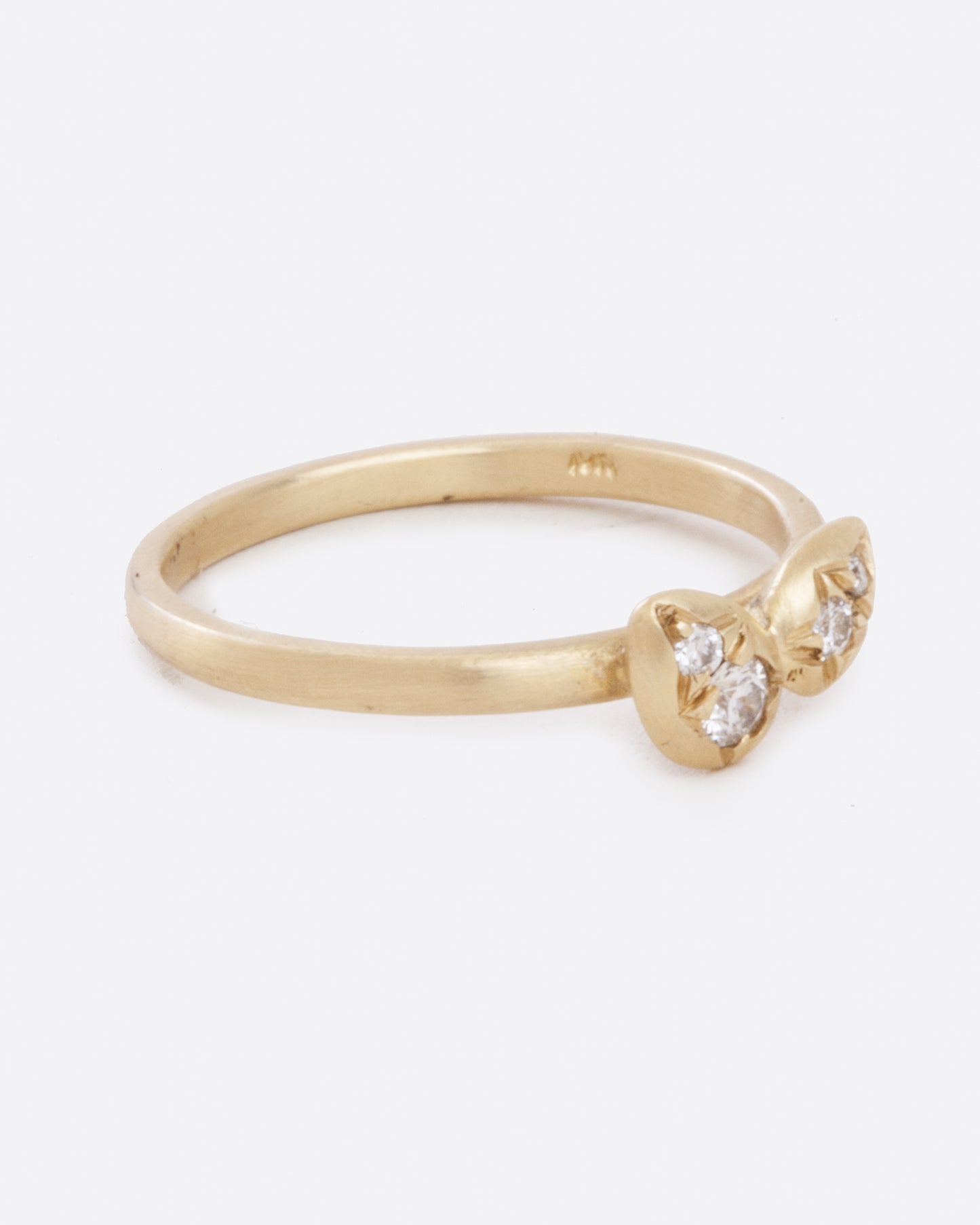 side view of simple 10k yellow gold band with four asymmetrical diamonds stacked in a central geometric cluster