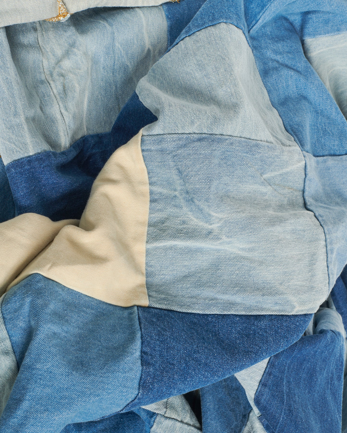 A handcrafted blanket made from pieces of dead stock denim, perfect for picnics.