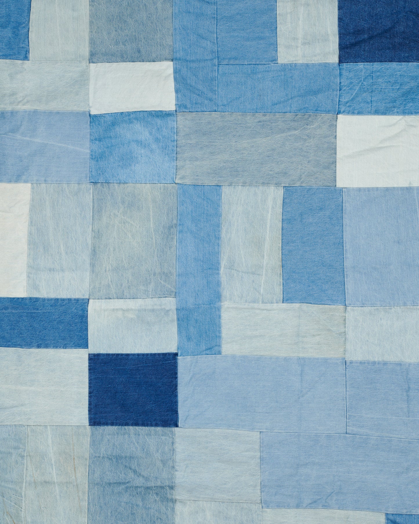 A handcrafted blanket made from pieces of dead stock denim, perfect for picnics.