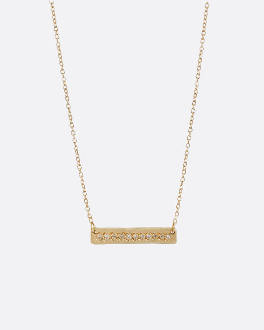 A yellow gold bar necklace with a single row of white diamonds.