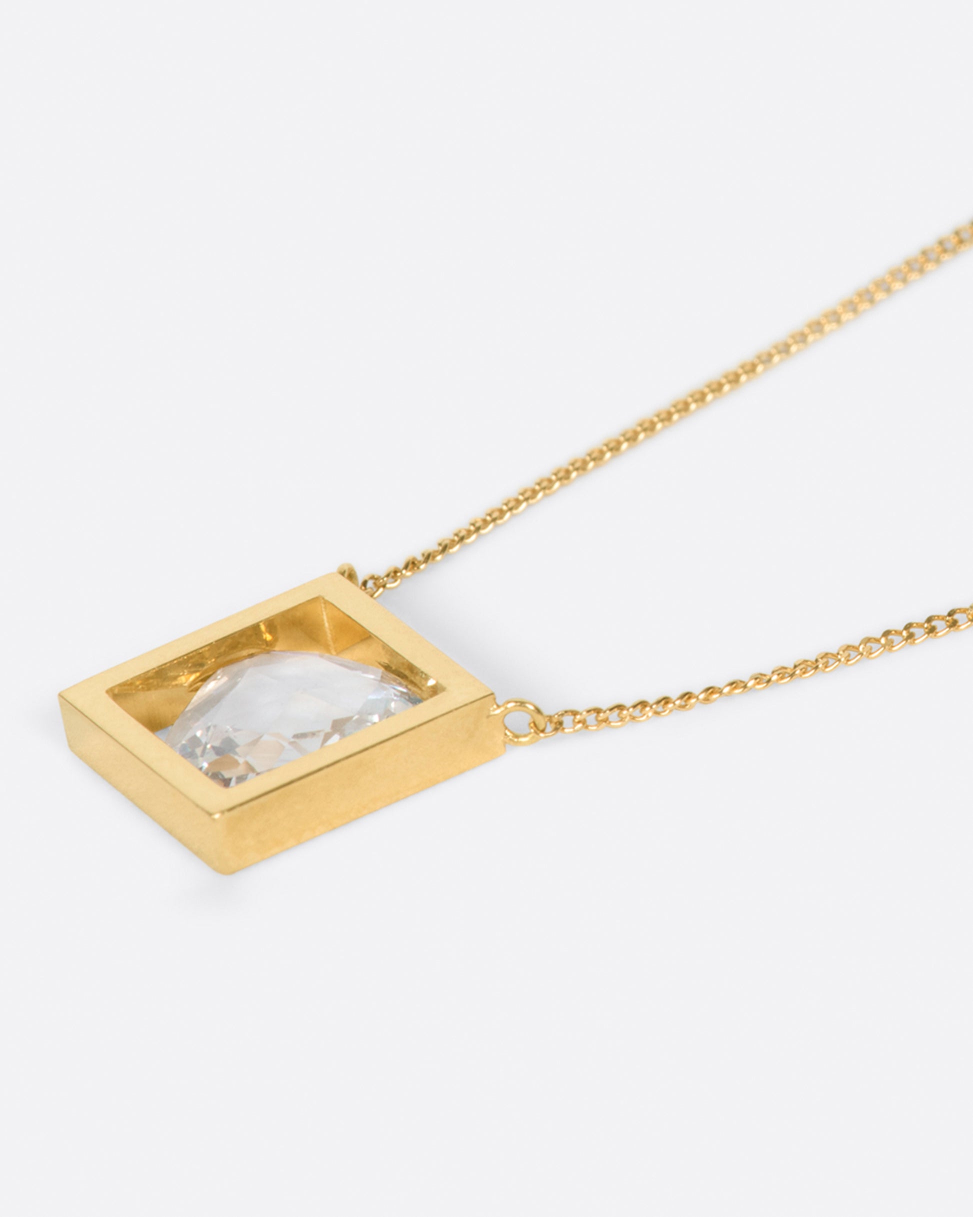 A square pendant necklace with a rose cut diamond inside, shown laying flat. 