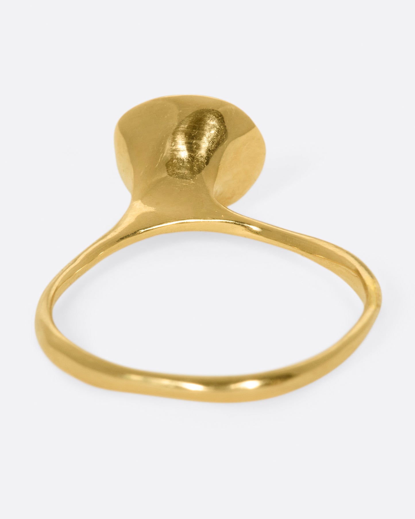 A wonky gold ring with a blue tourmaline cabochon set atop it.
