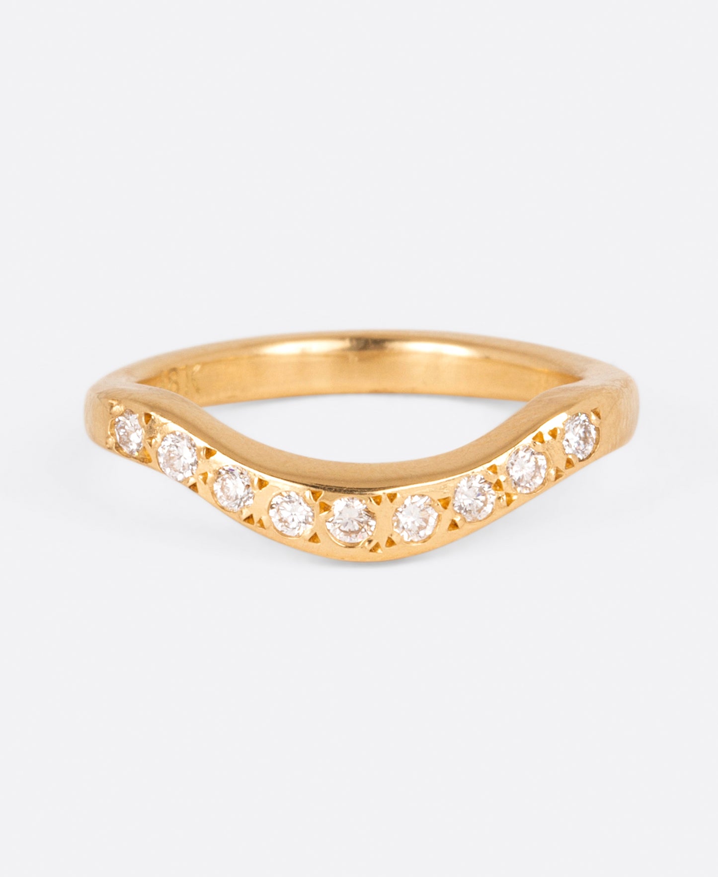 A curved yellow gold band with nine round white diamonds, shown from the front.