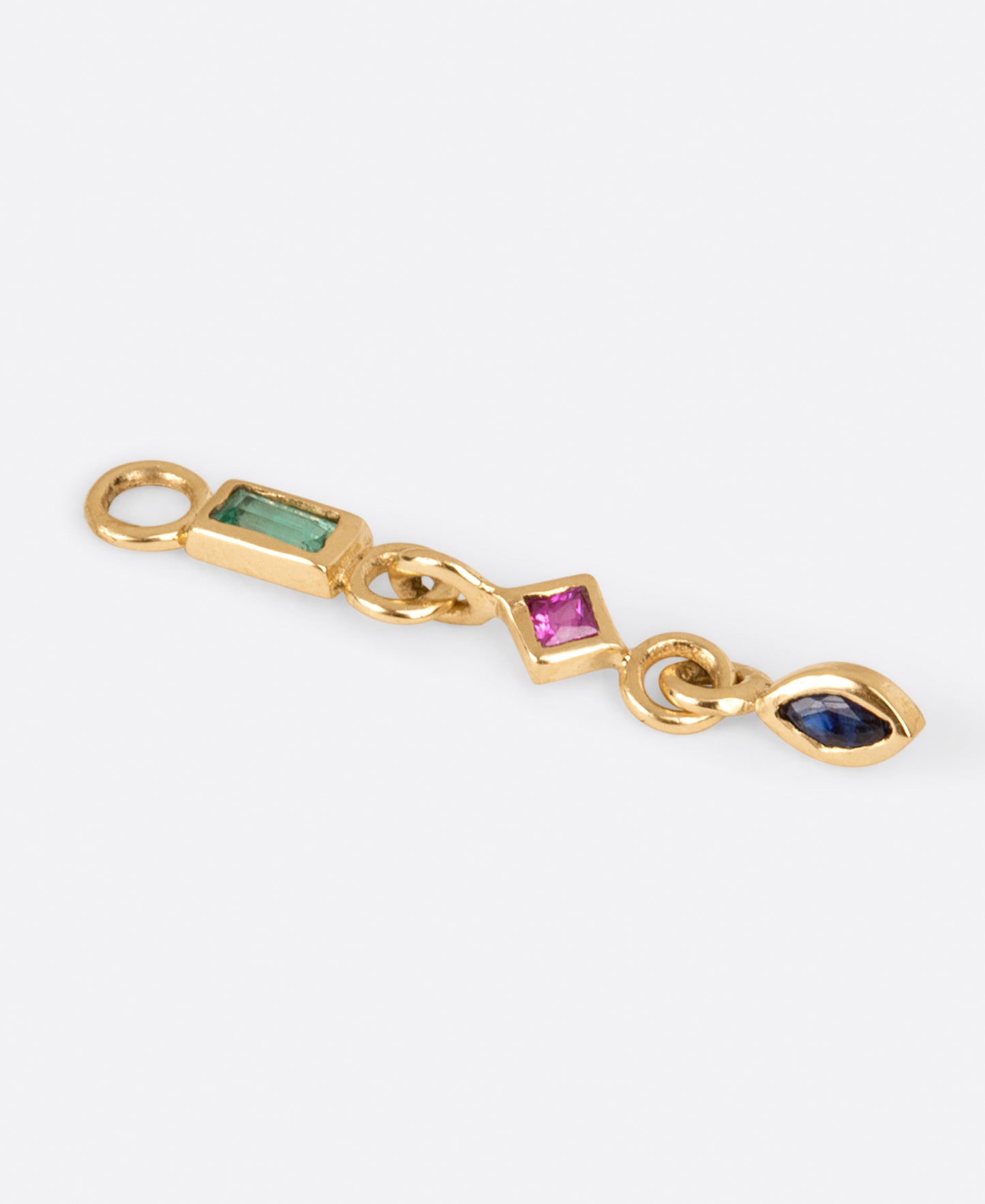 A yellow gold earring dangle with an emerald baguette, princess cut ruby, and marquis sapphire, shown from the side.