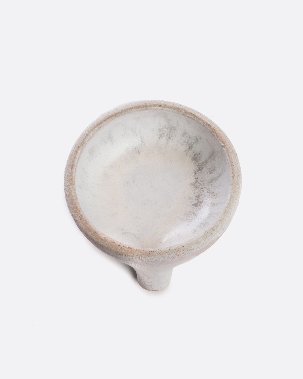 A black stoneware soap dish with a drainage spout. Shown from the top.