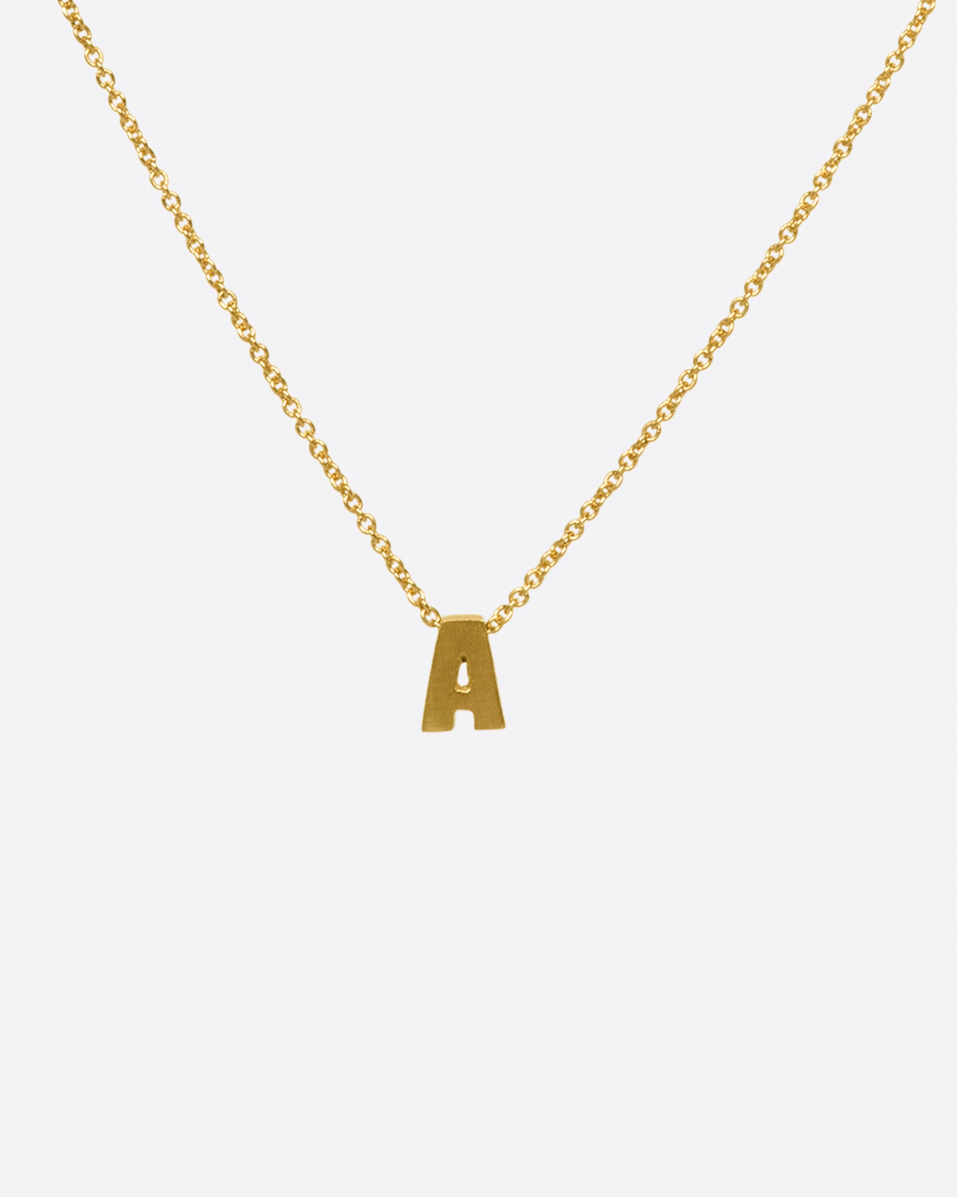 A yellow gold cable chain necklace with a letter A initial pendant. Shown from the front.