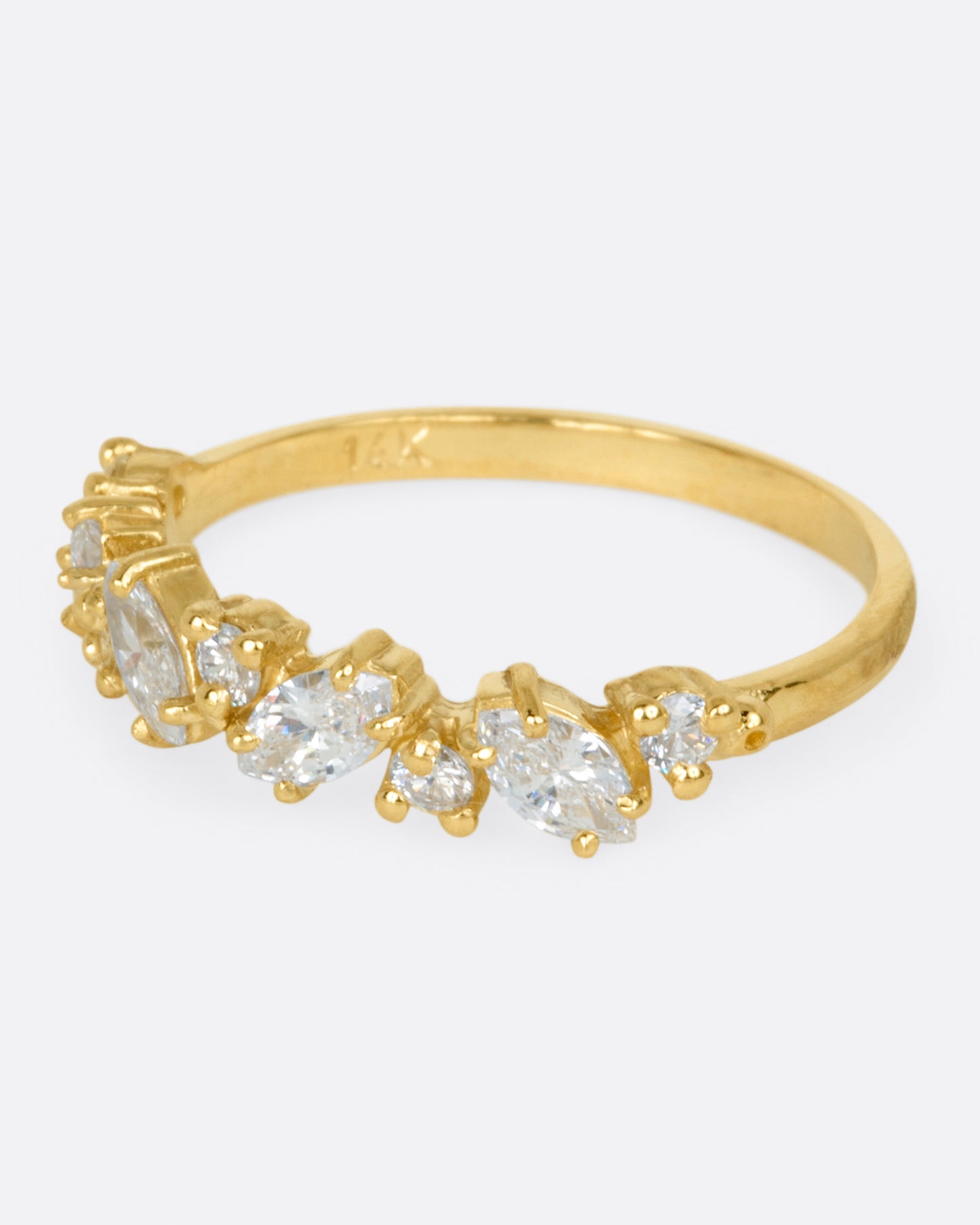 A yellow gold ring with round and marquise diamonds. Shown from the side.