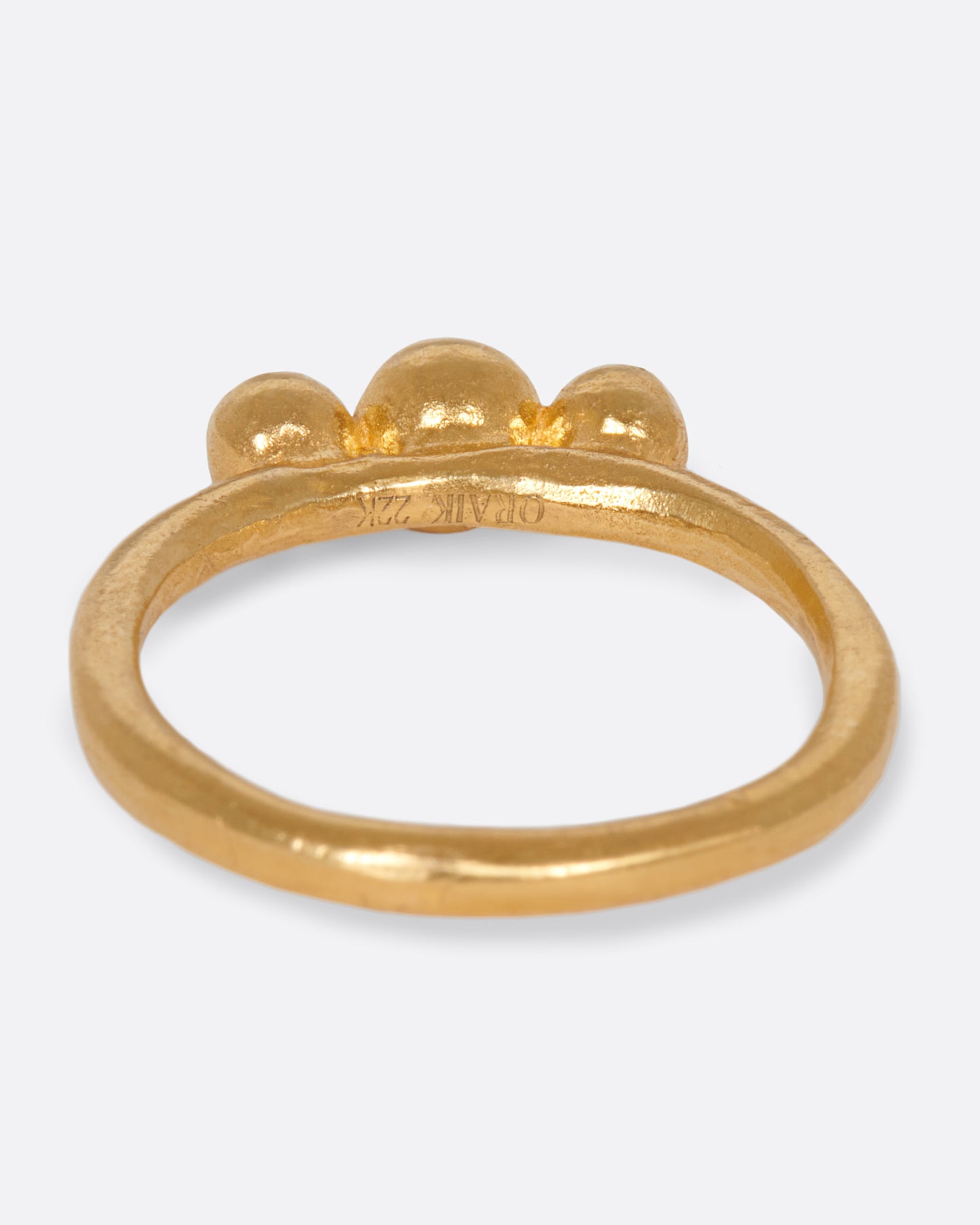 A handmade, high karat gold ring with three vibrant, bezel set aquamarines.