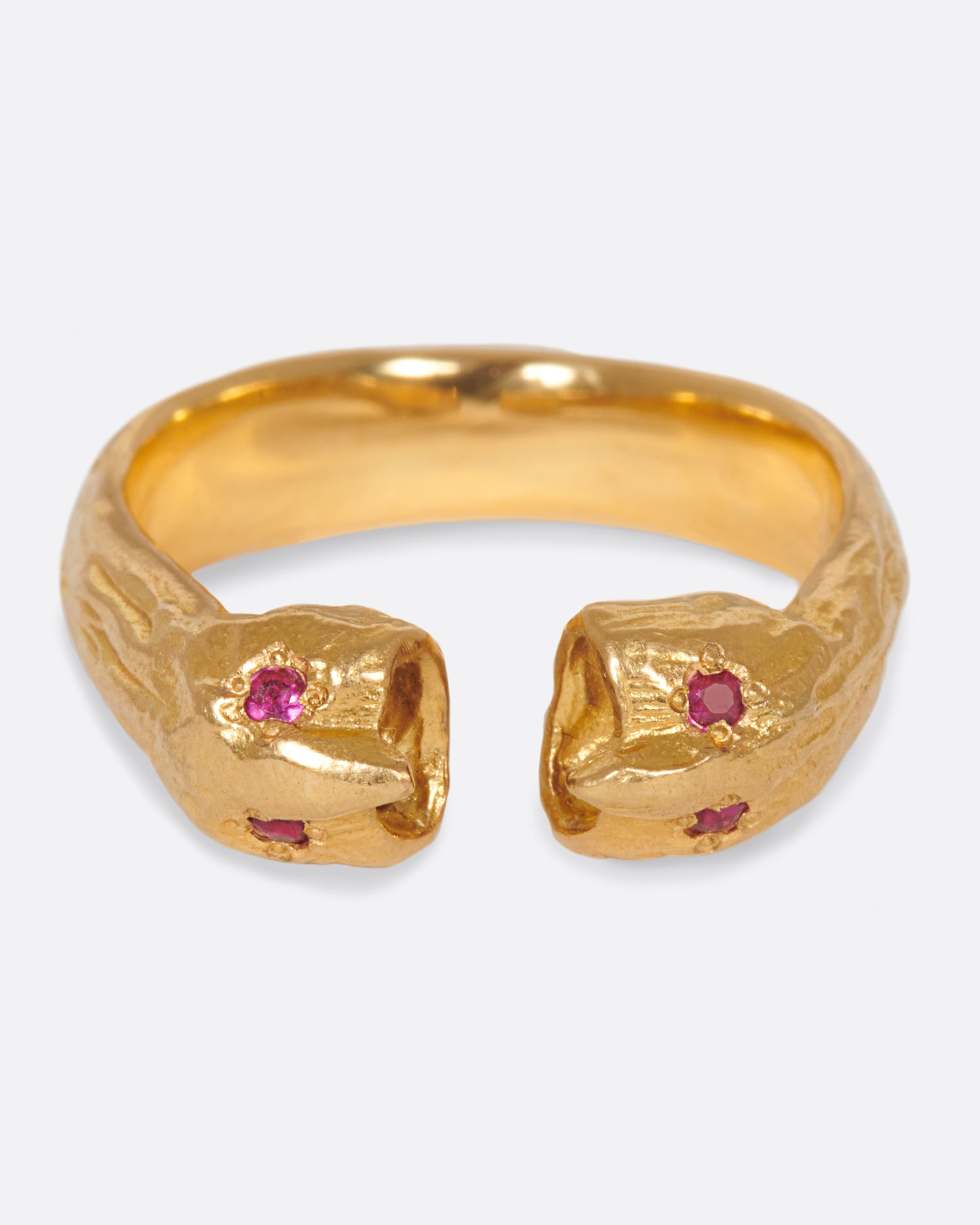 A yellow gold open ring with two ruby eyed faces facing each other. Shown from the front.