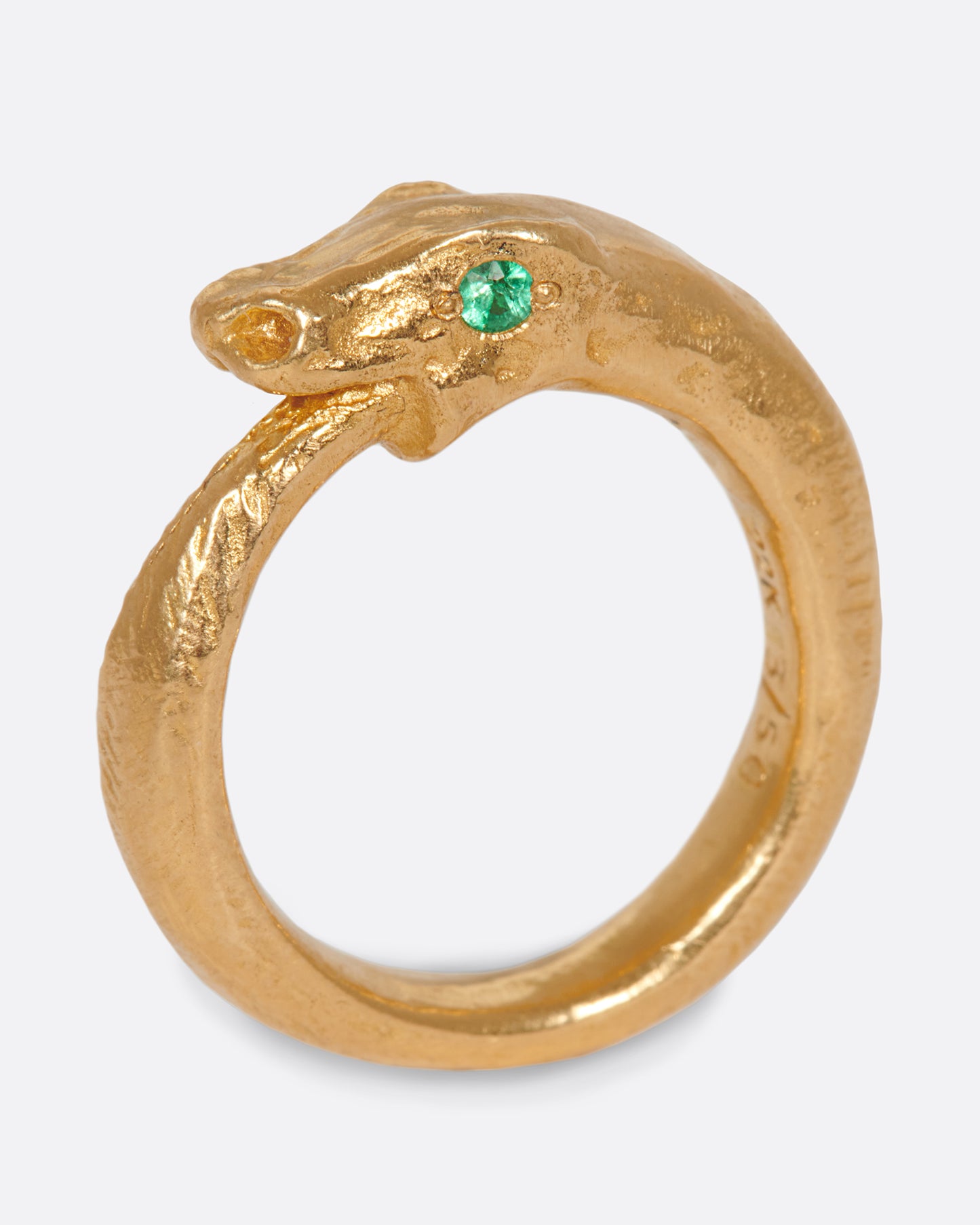 A yellow gold ouroboros ring with a emerald eyed serpent catching its own tail. Shown standing up from the side.