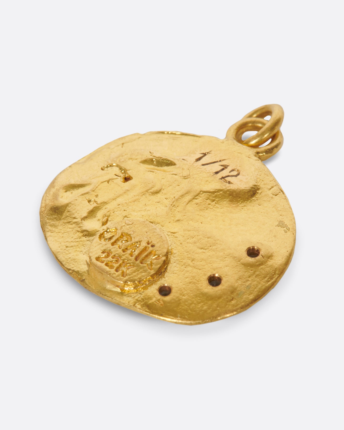 A hand formed medallion pendant with an Aquarius icon, pouring water dotted with aquamarines.