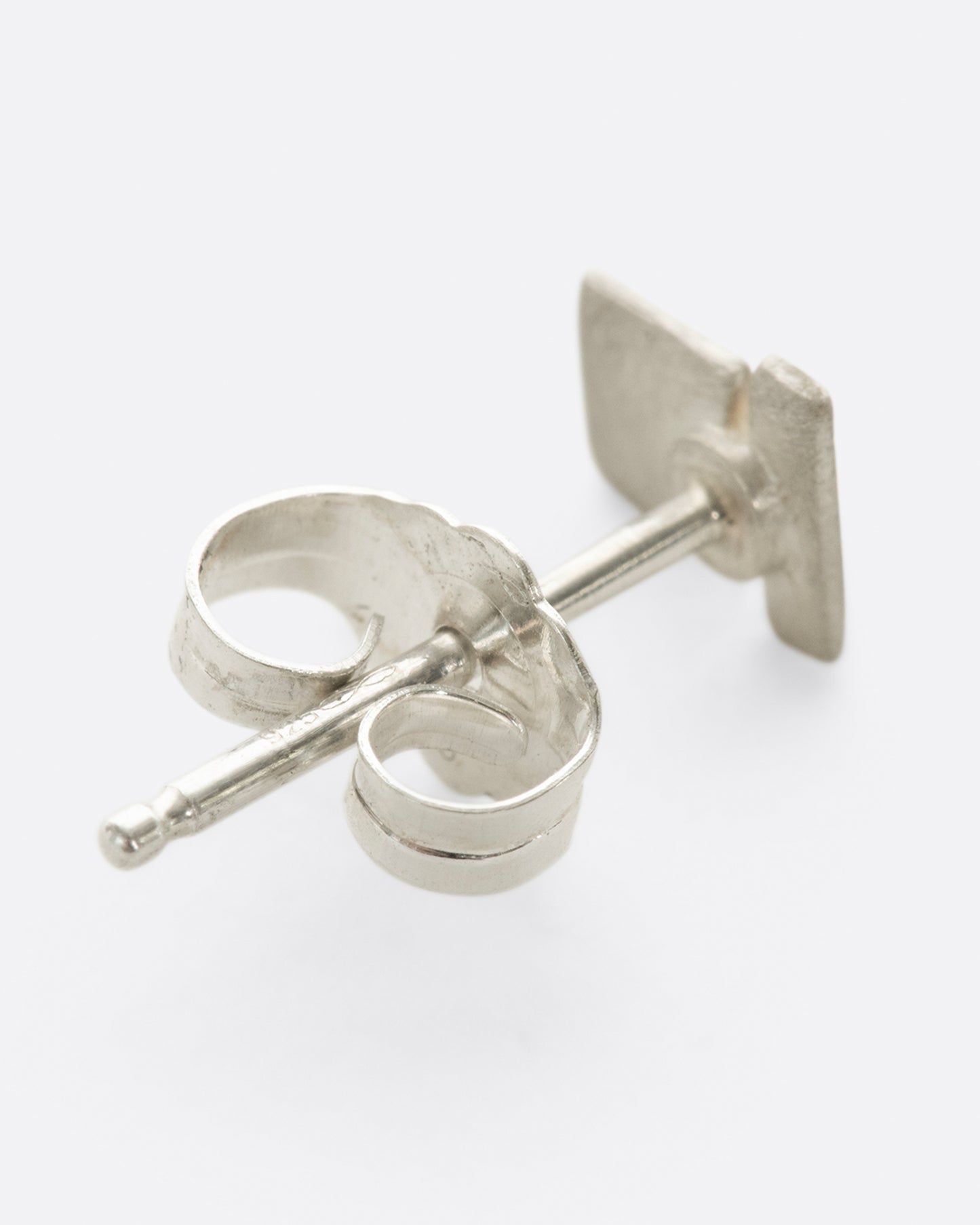 A brushed sterling silver stud earring with two rectangles stacked. Shown lying flat from the back.