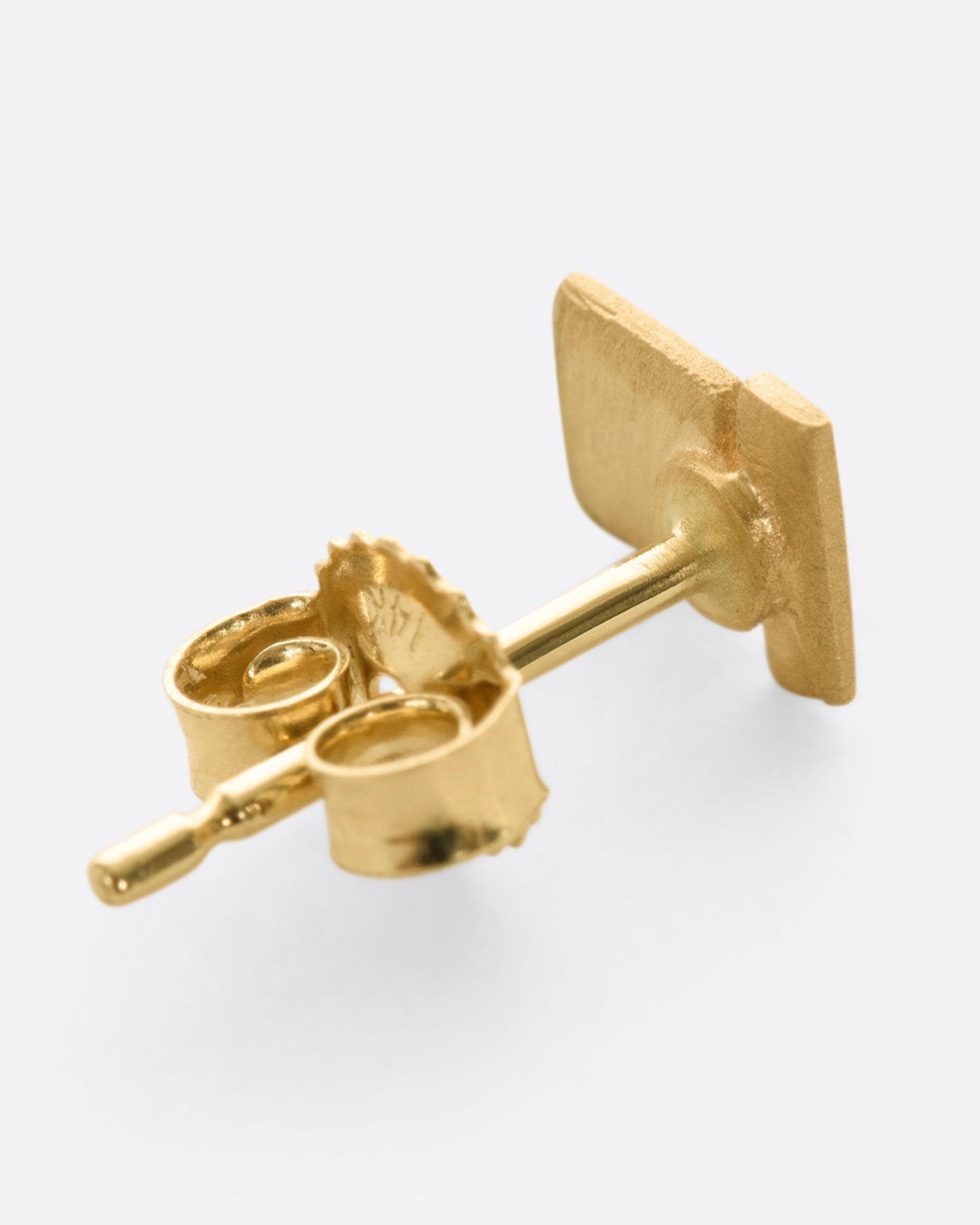 A yellow gold stacked geometric stud earring with matte finish.