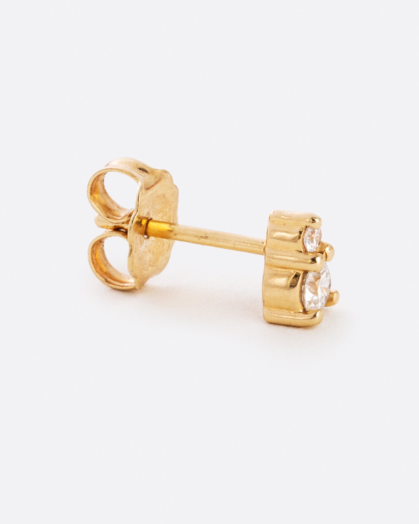 A yellow gold earring with two diamonds stacked. Shown from the side.