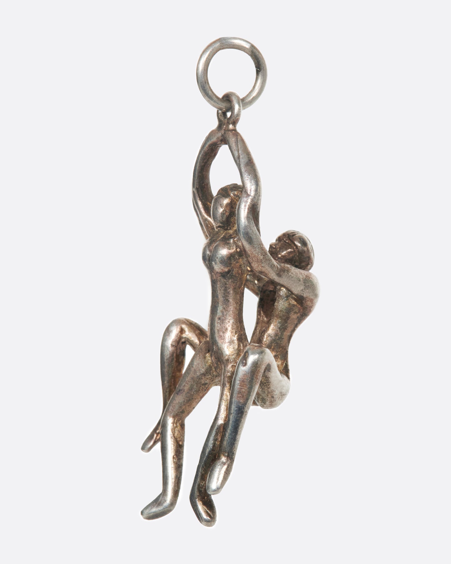 A vintage silver pendant of a couple enjoying a bit of TLC.