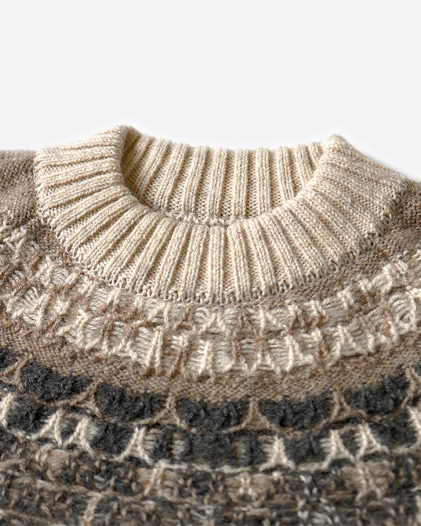 A close up of the Nordic pattern around the collar of a crewneck pullover sweater. Shown from the front.