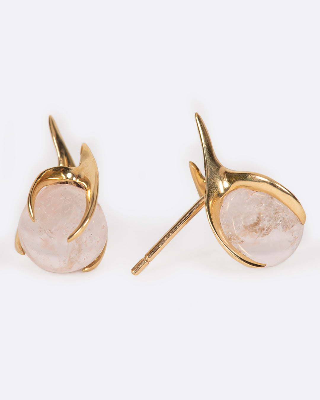 A pair of yellow gold earrings with claw prong settings holding morganite spheres. One earring is shown from the front, the other from the side.