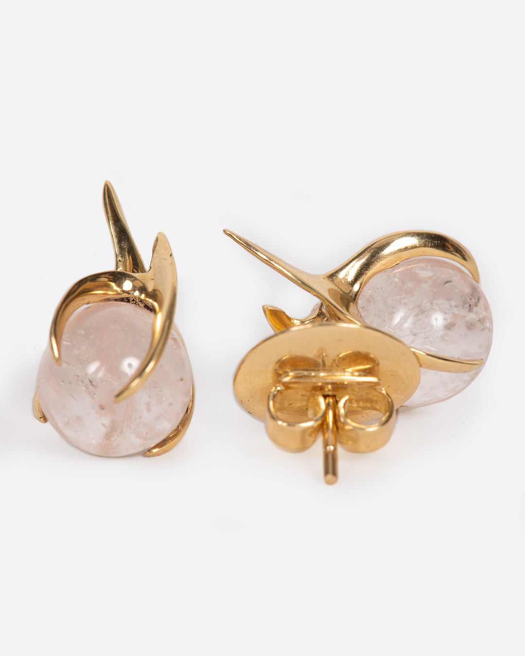 A pair of yellow gold earrings with claw prong settings holding morganite spheres. One earring is shown from the front, the other from the back.