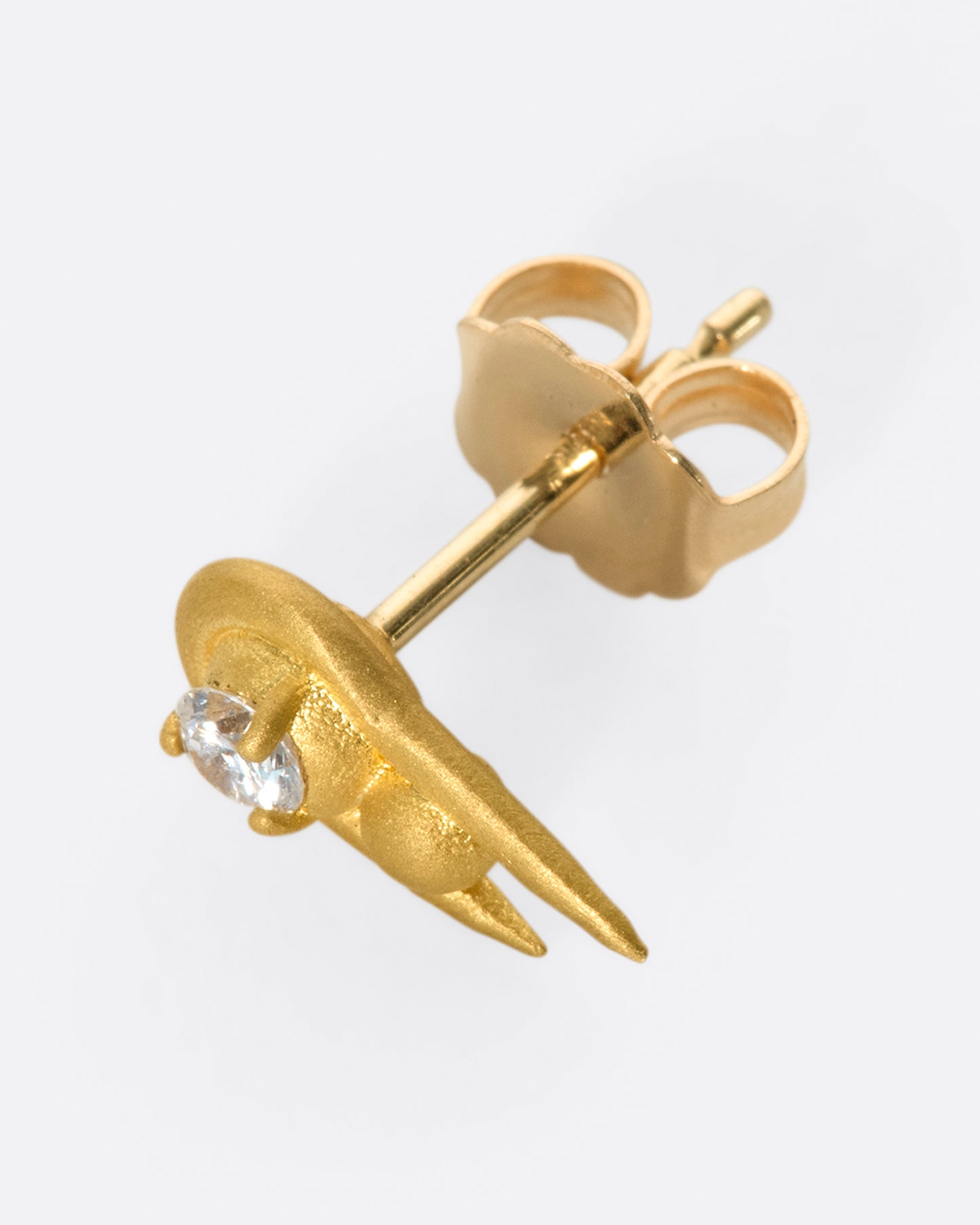 A curved high karat gold earring with a stacked sphere and brilliant cut diamond. Shown from the side.