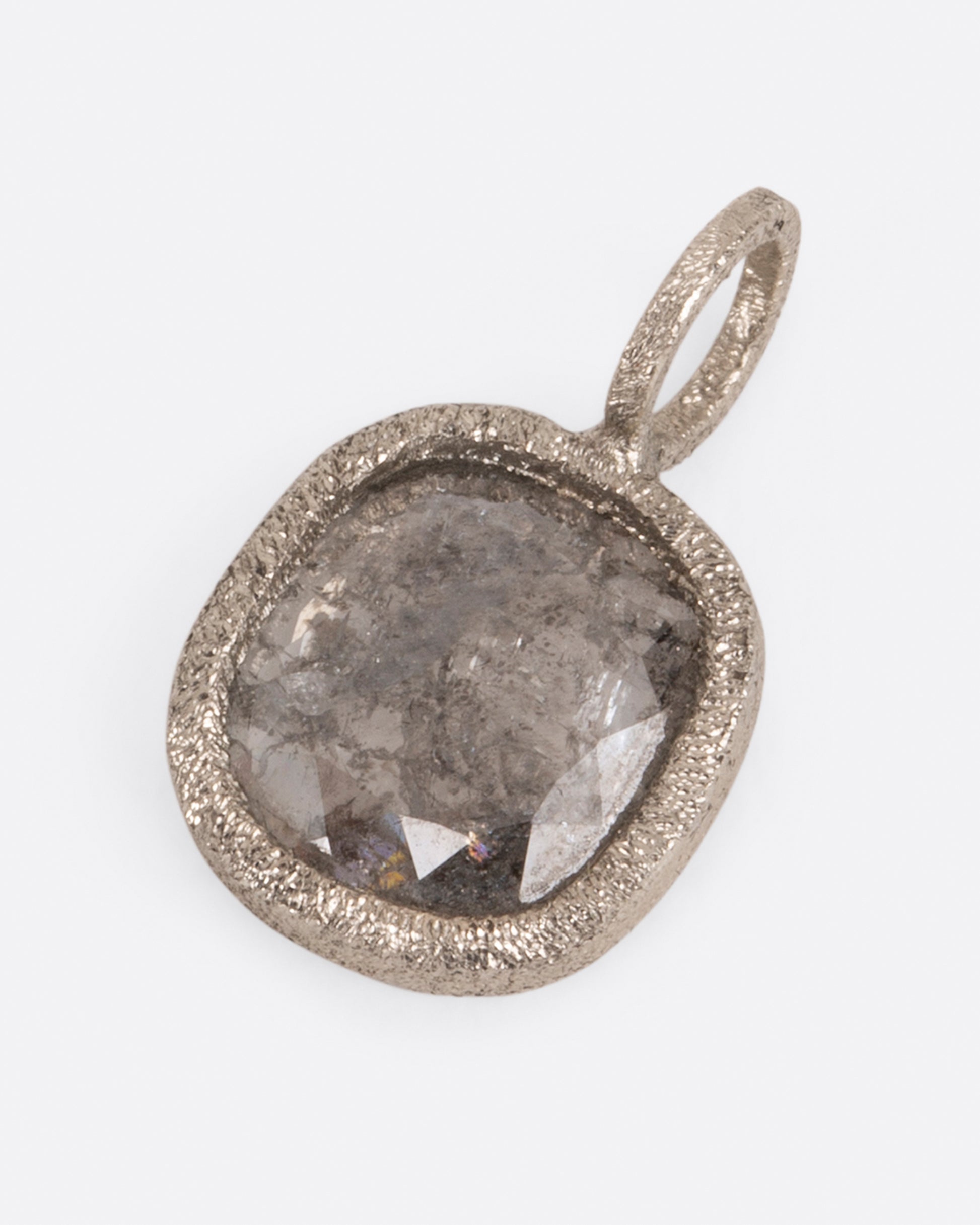 A pendant with a square salt and pepper diamond set in white gold. Shown lying flat from the front.