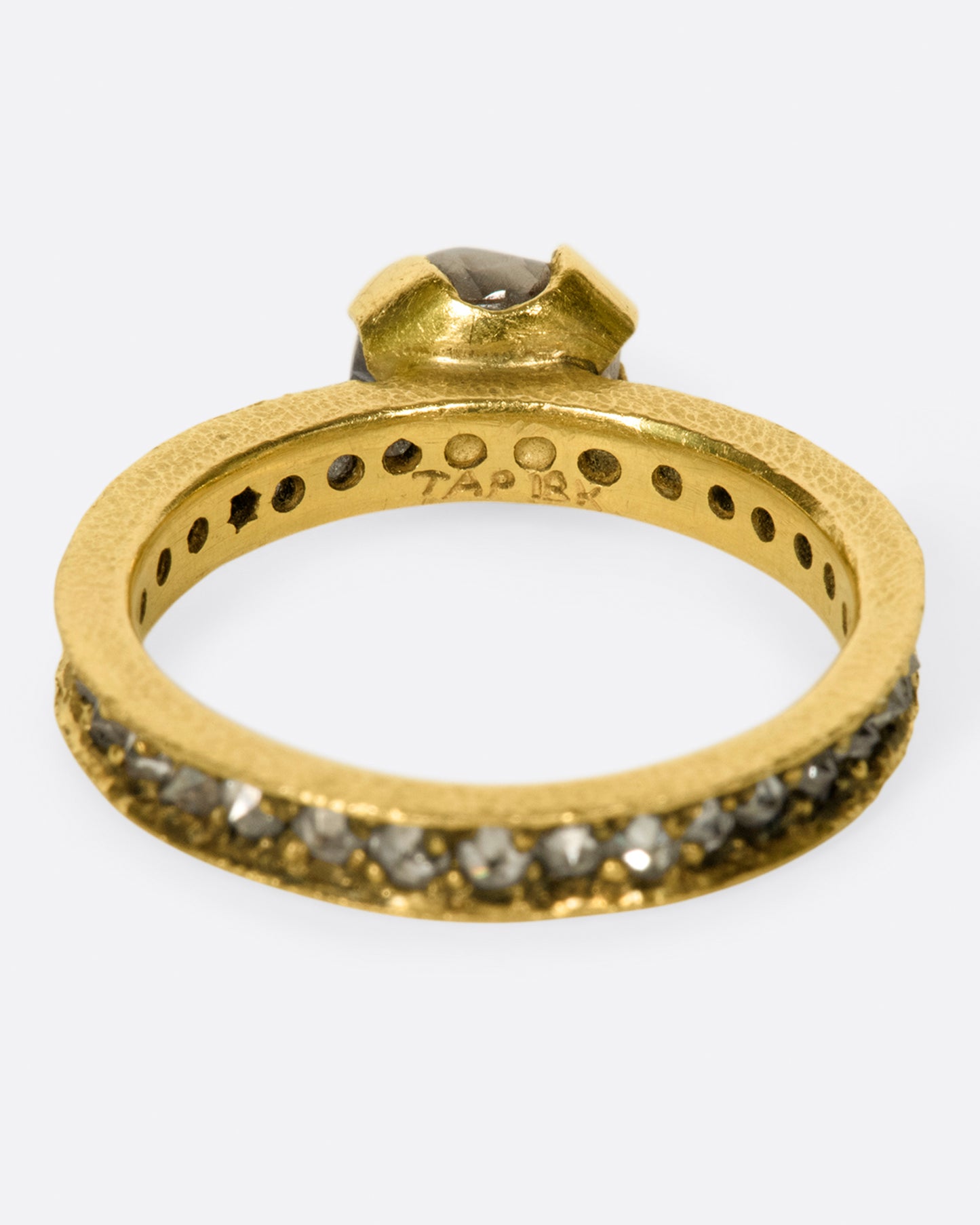 A yellow eternity band with inverted diamonds, crowned by a prong set raw yellow diamond.