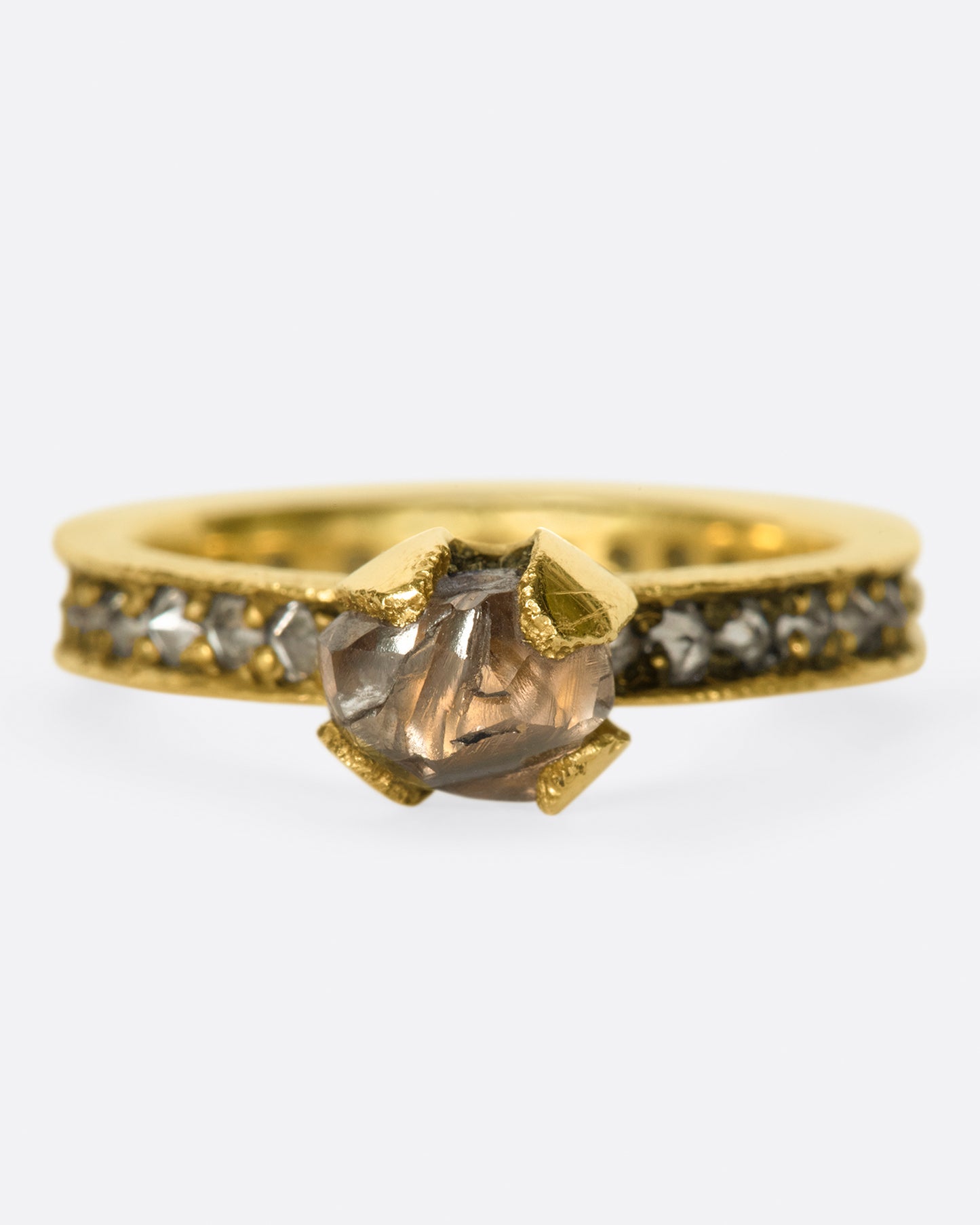 A yellow eternity band with inverted diamonds, crowned by a prong set raw yellow diamond.