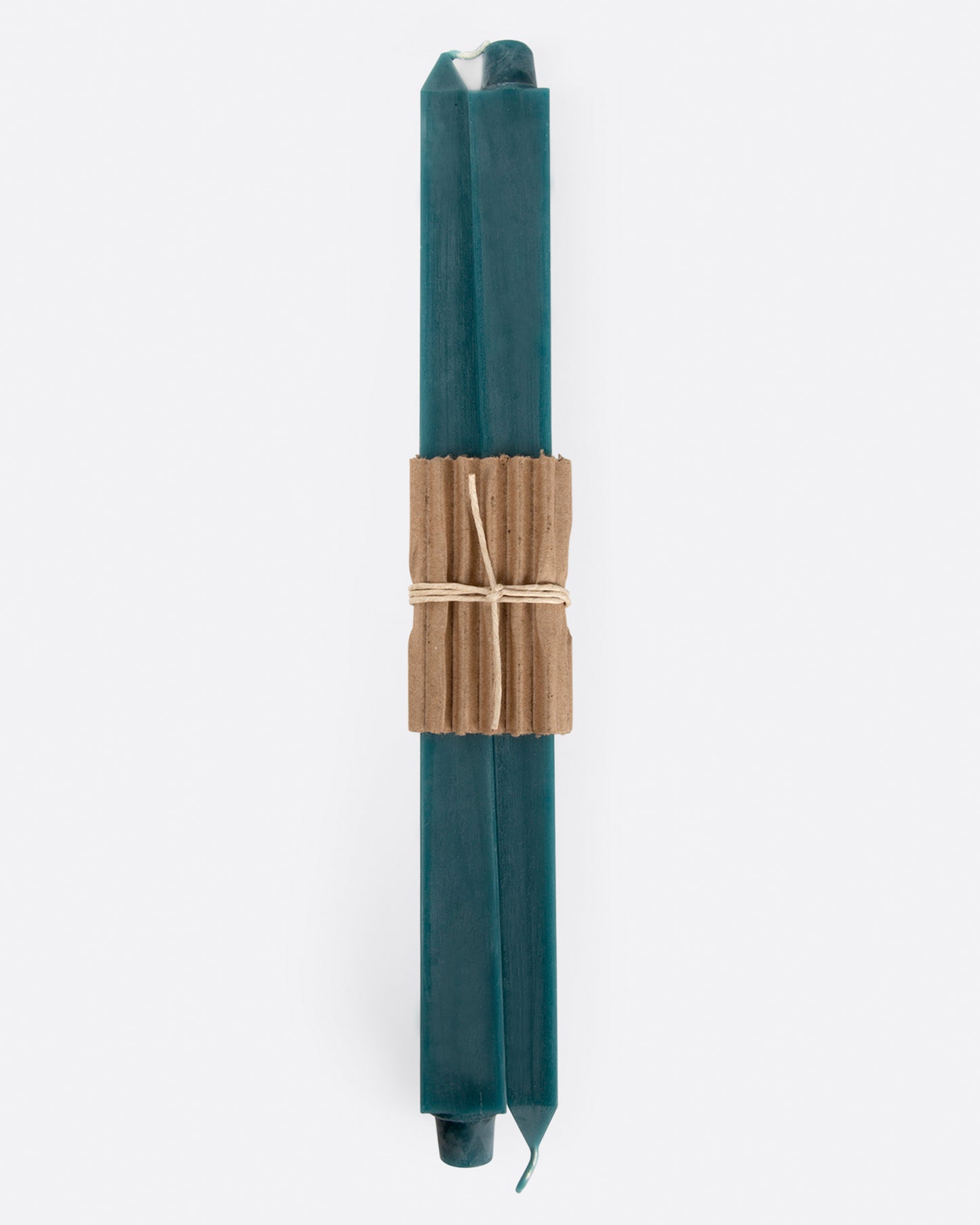 Turquoise square taper candles lying flat with cardboard wrapping at the center. Shown from the front.