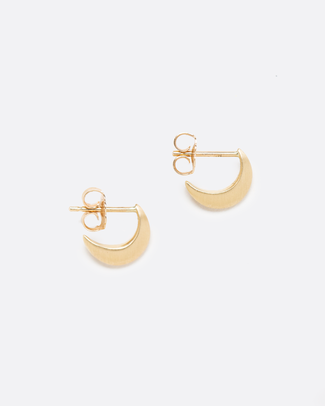 A pair of yellow gold crescent moon shaped earrings with stud backs. Shown from the side.