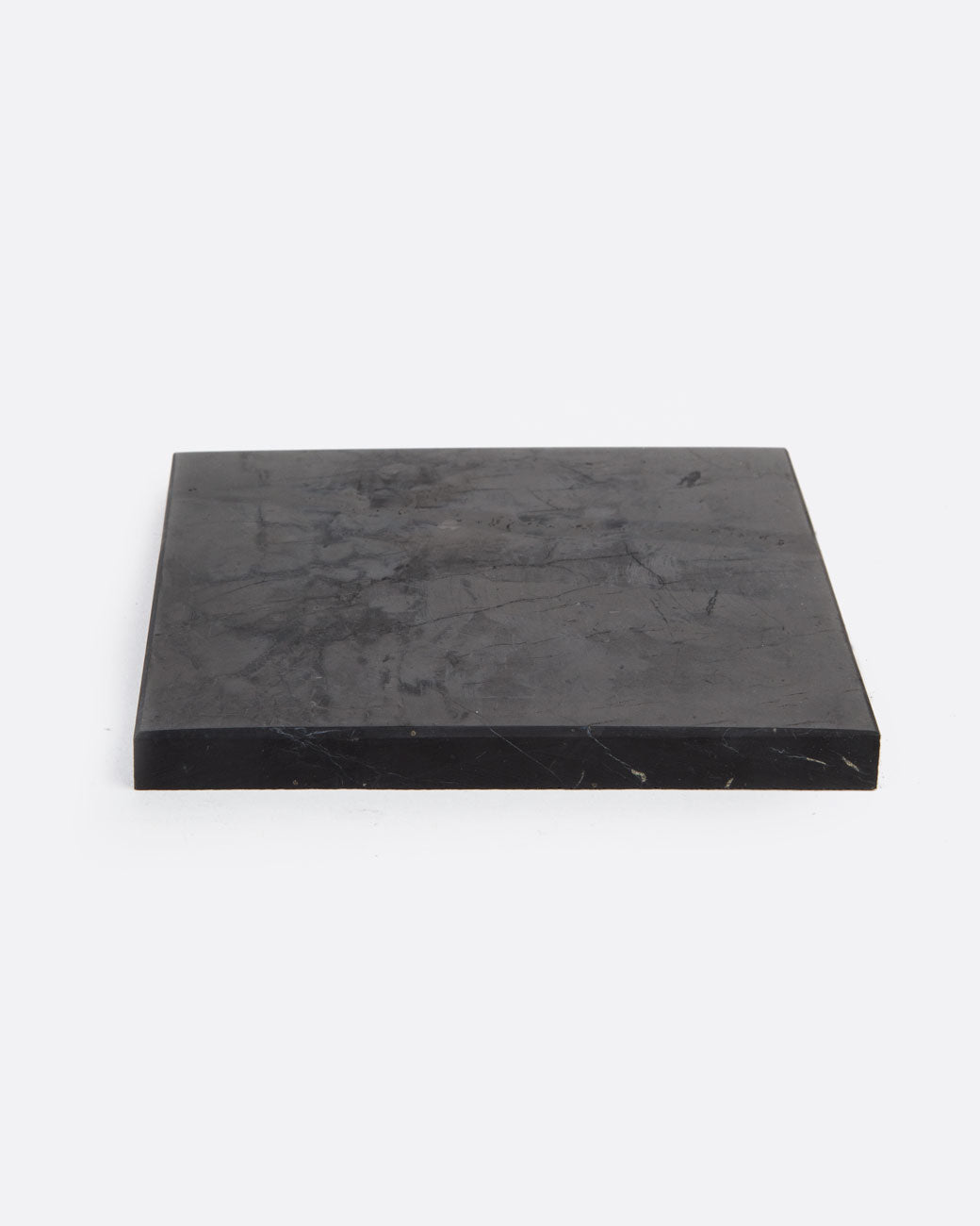 A black stone tile shown lying flat from the front.