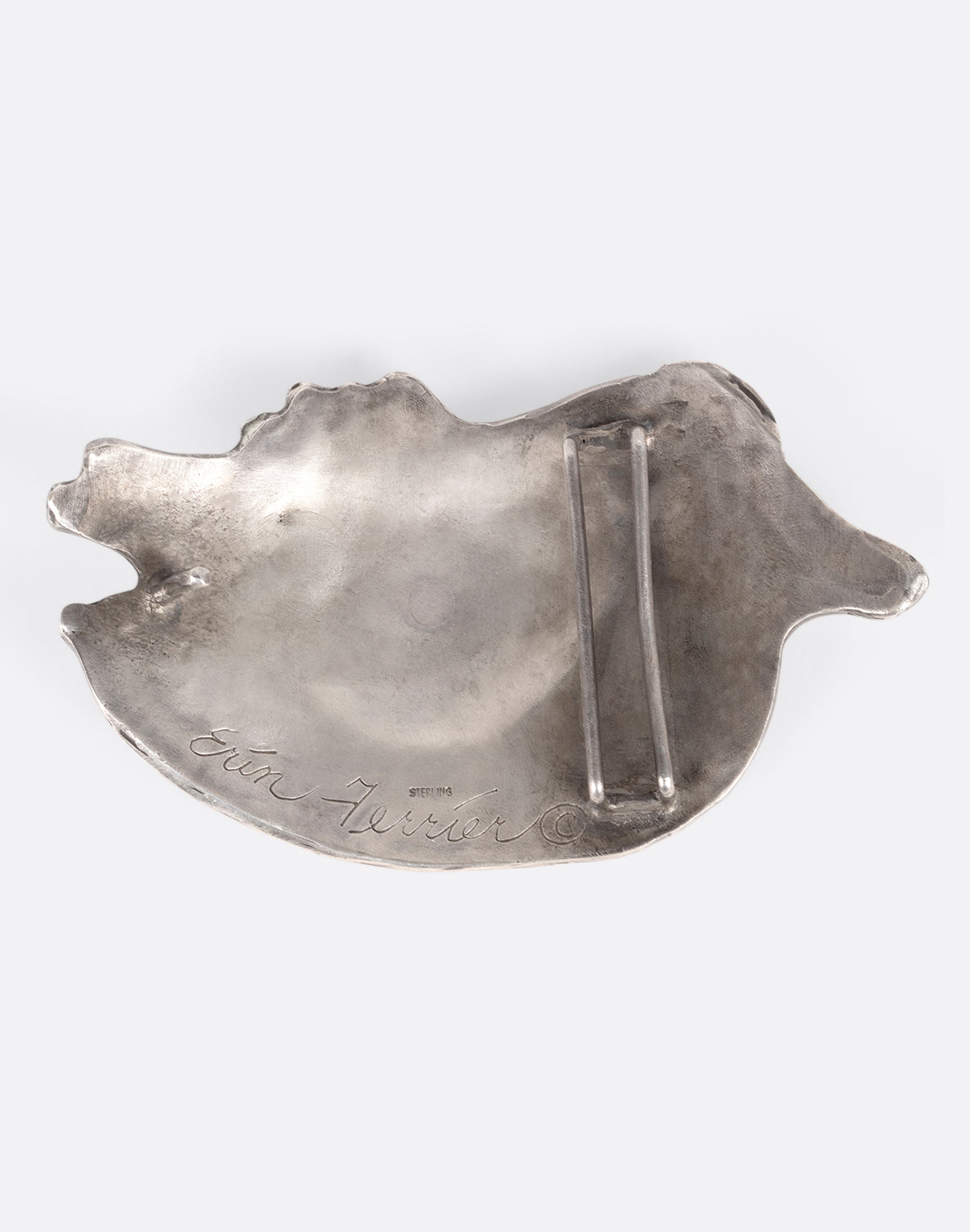 A silver ram belt buckle shown from the back.