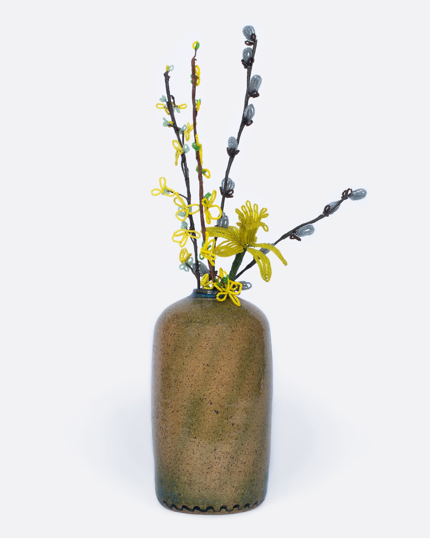 A cylindrical brown vase with swirls of blue and green glaze.