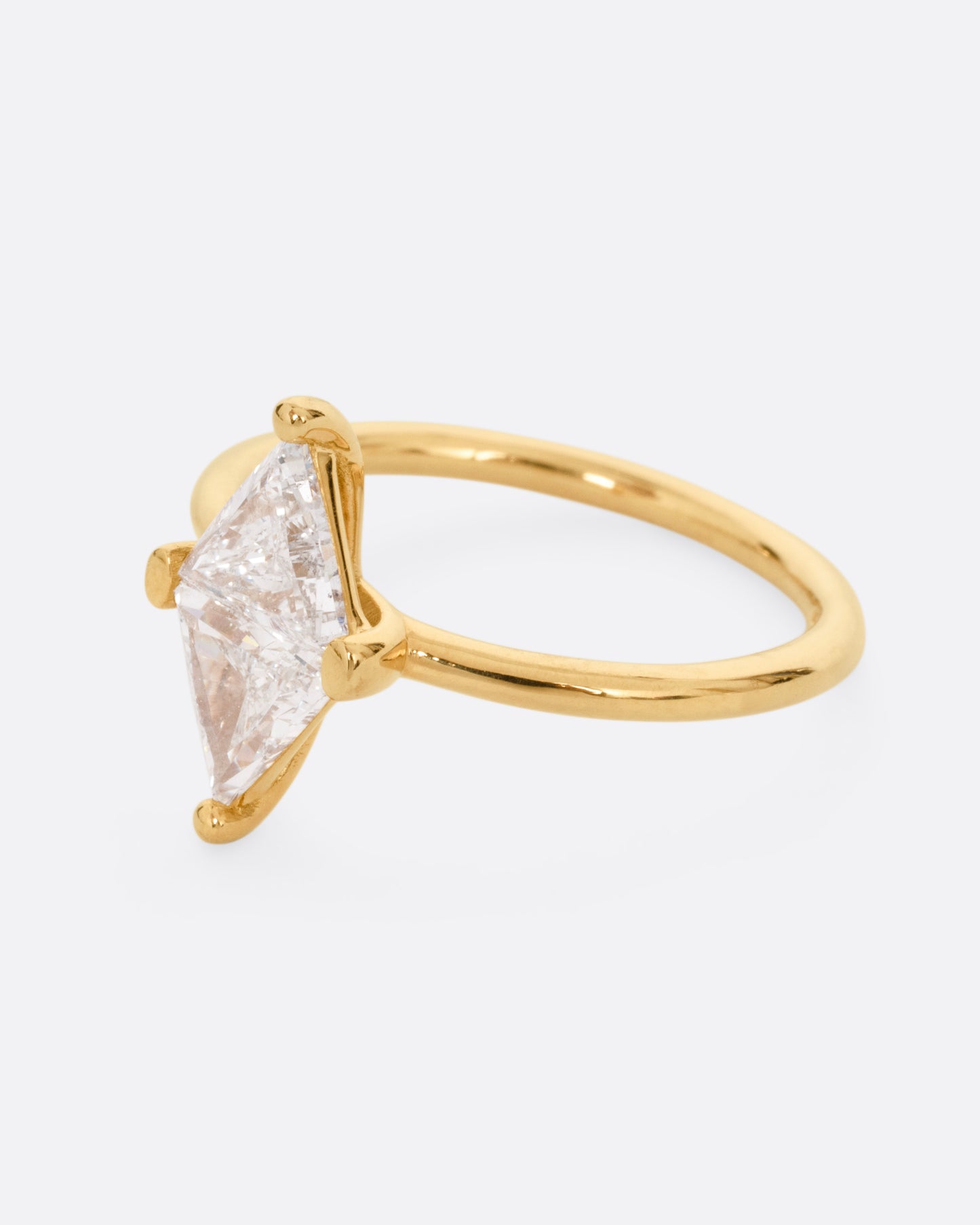 A yellow gold ring with two triangular diamonds mirroring each other. Shown from the side.