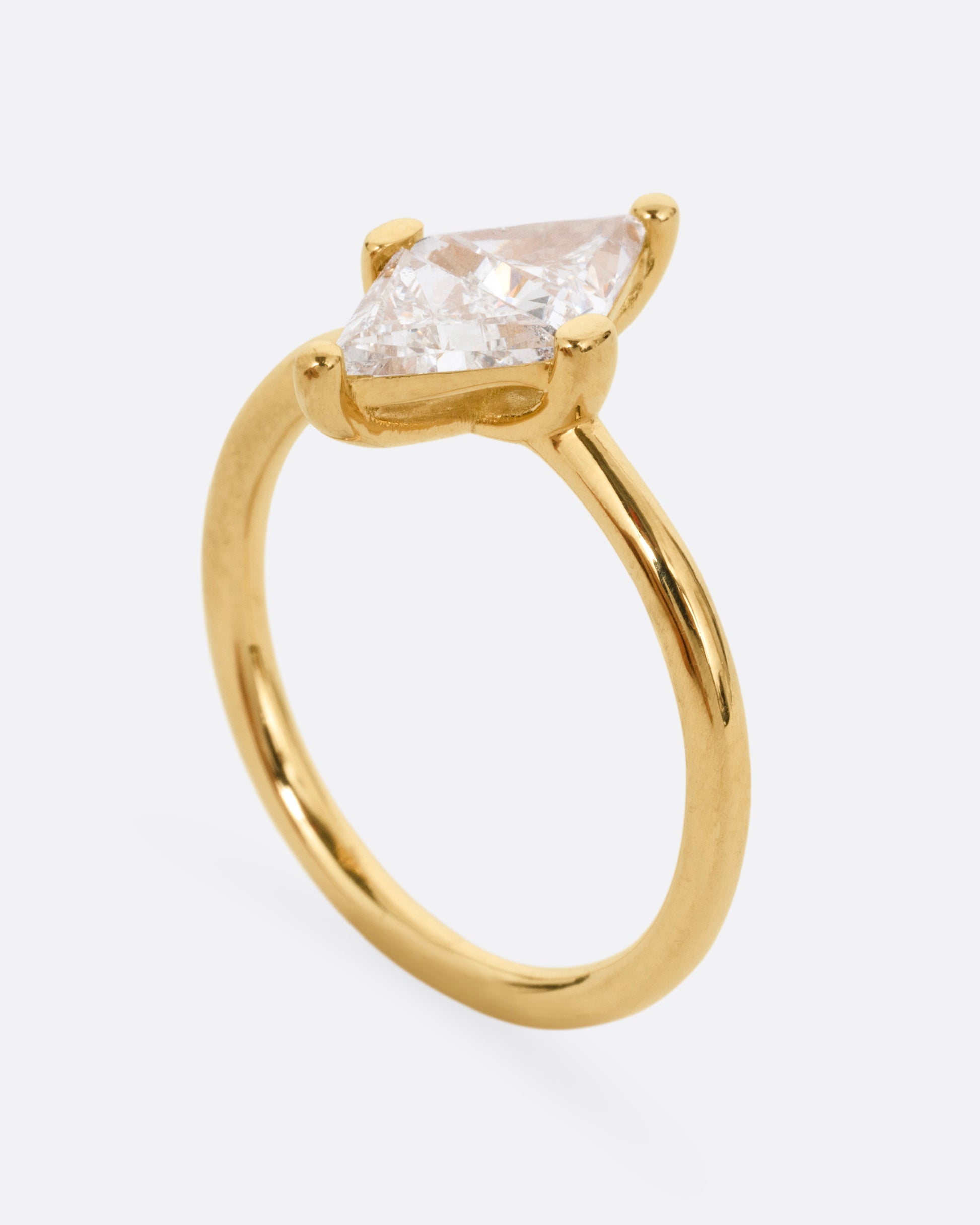A yellow gold ring with two triangular diamonds mirroring each other. Shown from the side standing up.