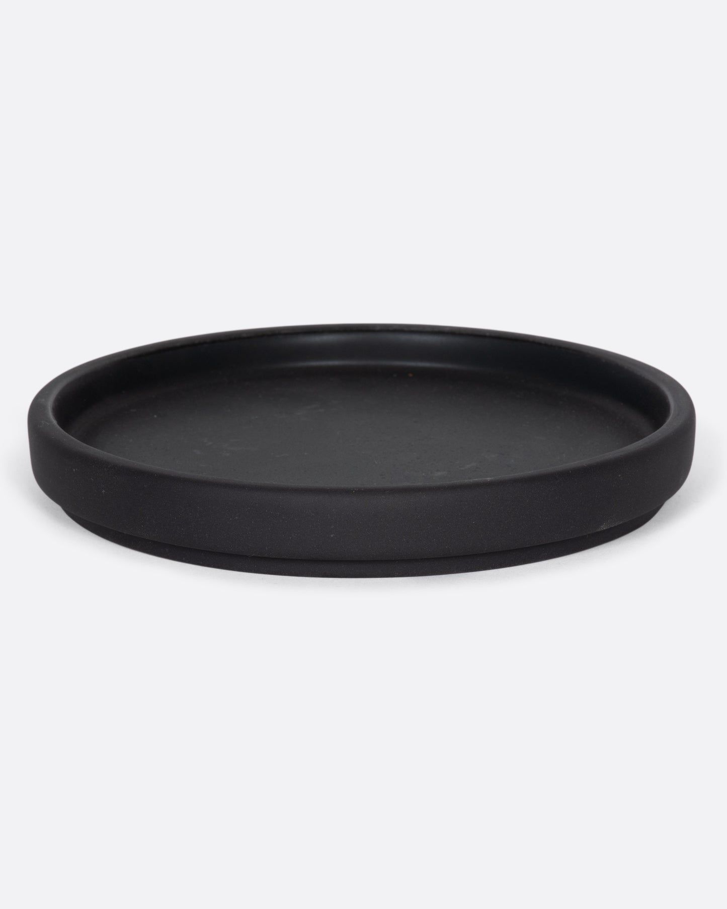 This black ceramic plate with a raised lip and matte black finish looks beautiful with tall candles and works great for small plants, too.