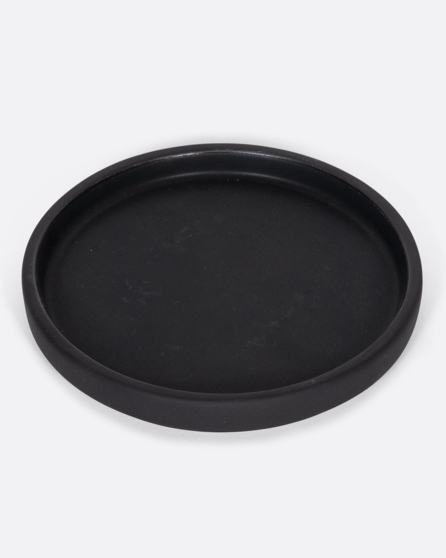 This black ceramic plate with a raised lip and matte black finish looks beautiful with tall candles and works great for small plants, too.